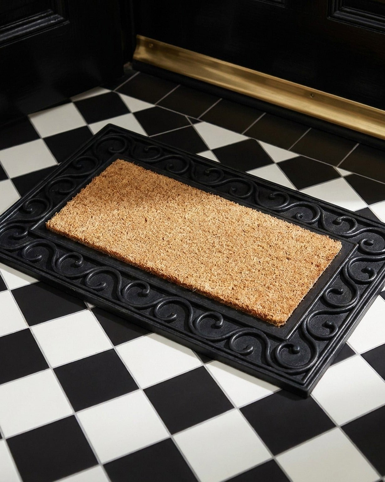 Doormat with decorative black border on a checkered floor