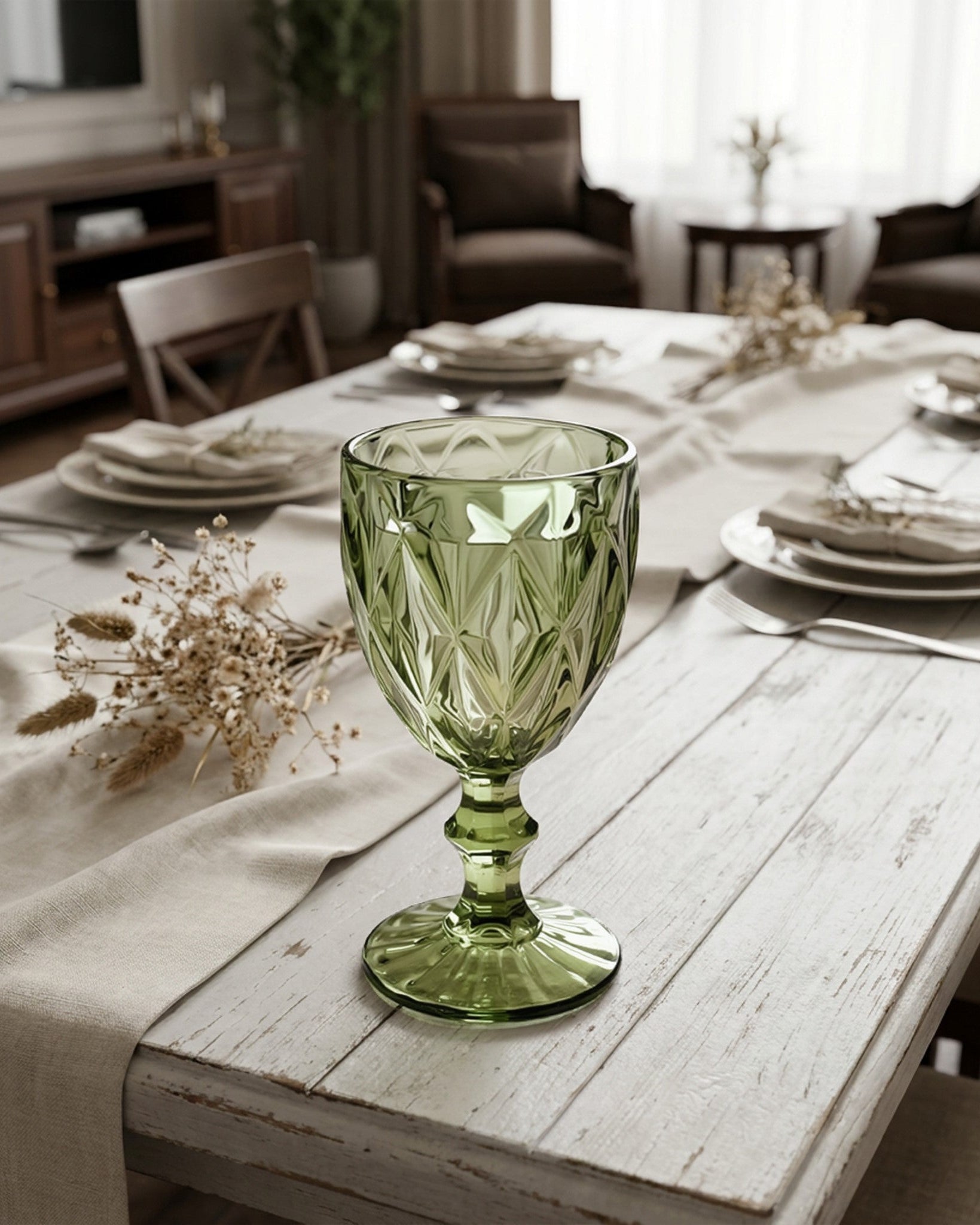 Green glass on a wooden table with a dining room setting in the background