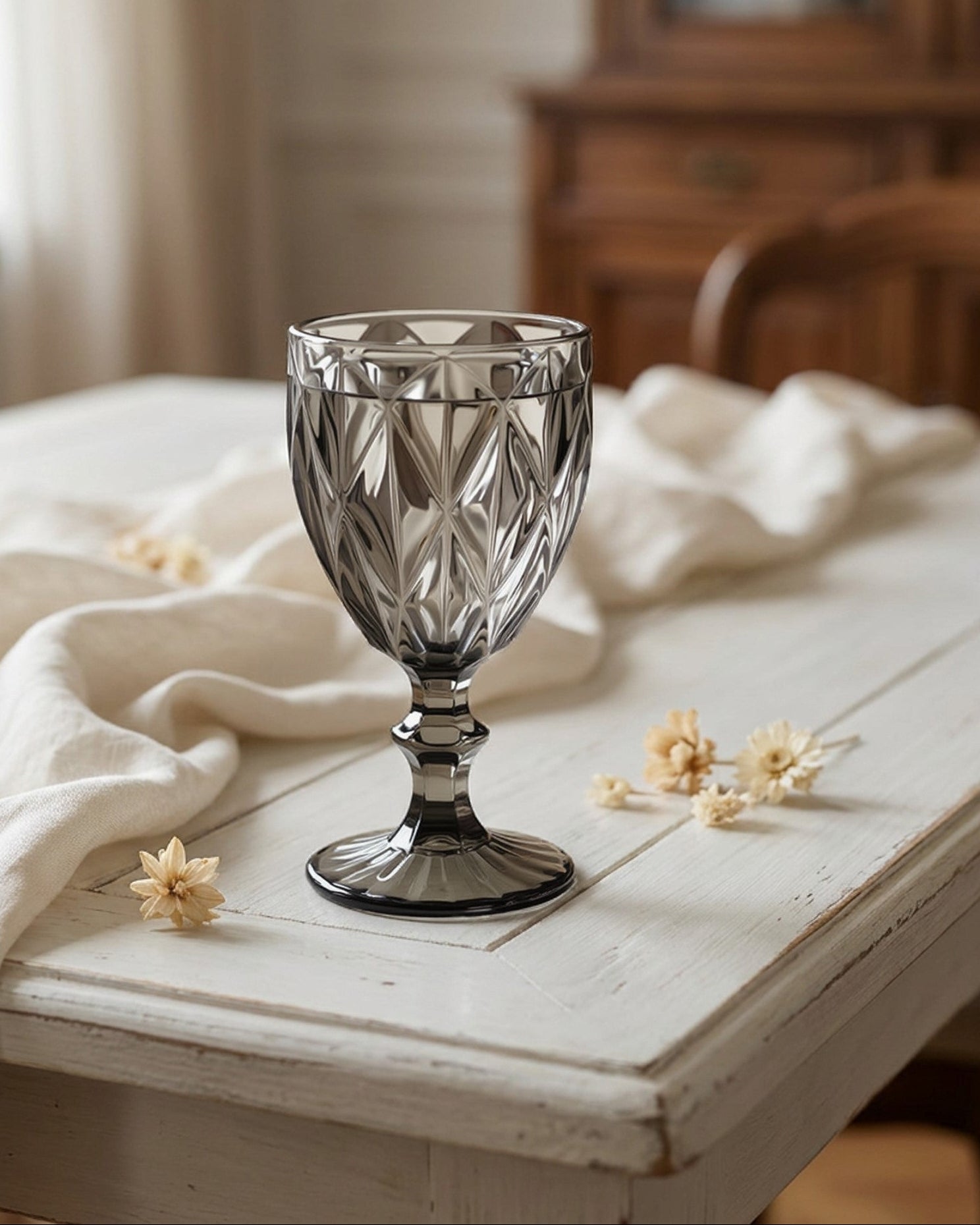 Decorative glass on a wooden table with flowers and a blurred background