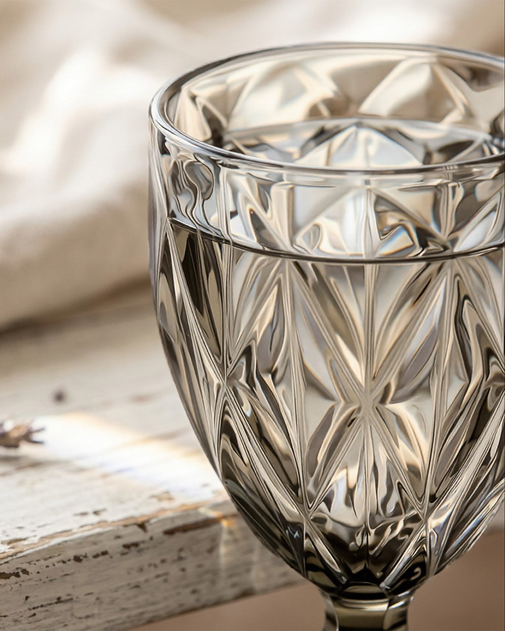 Decorative glass goblet with intricate patterns on a wooden surface.