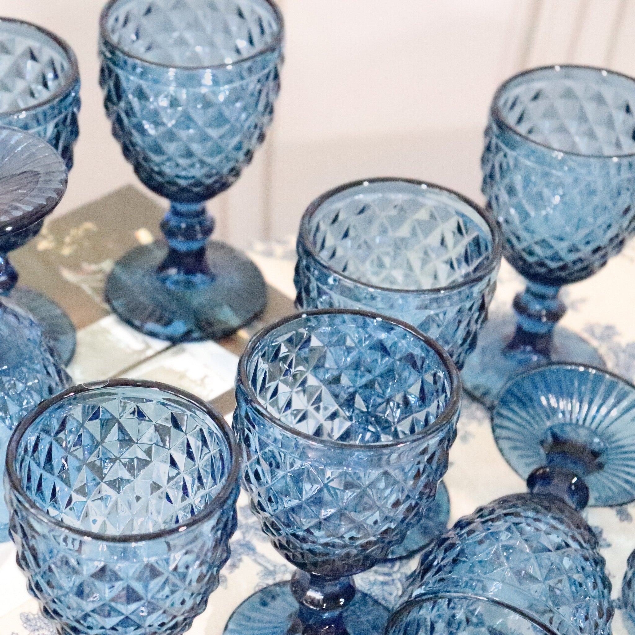 Set of blue glass goblets with textured design on a light background