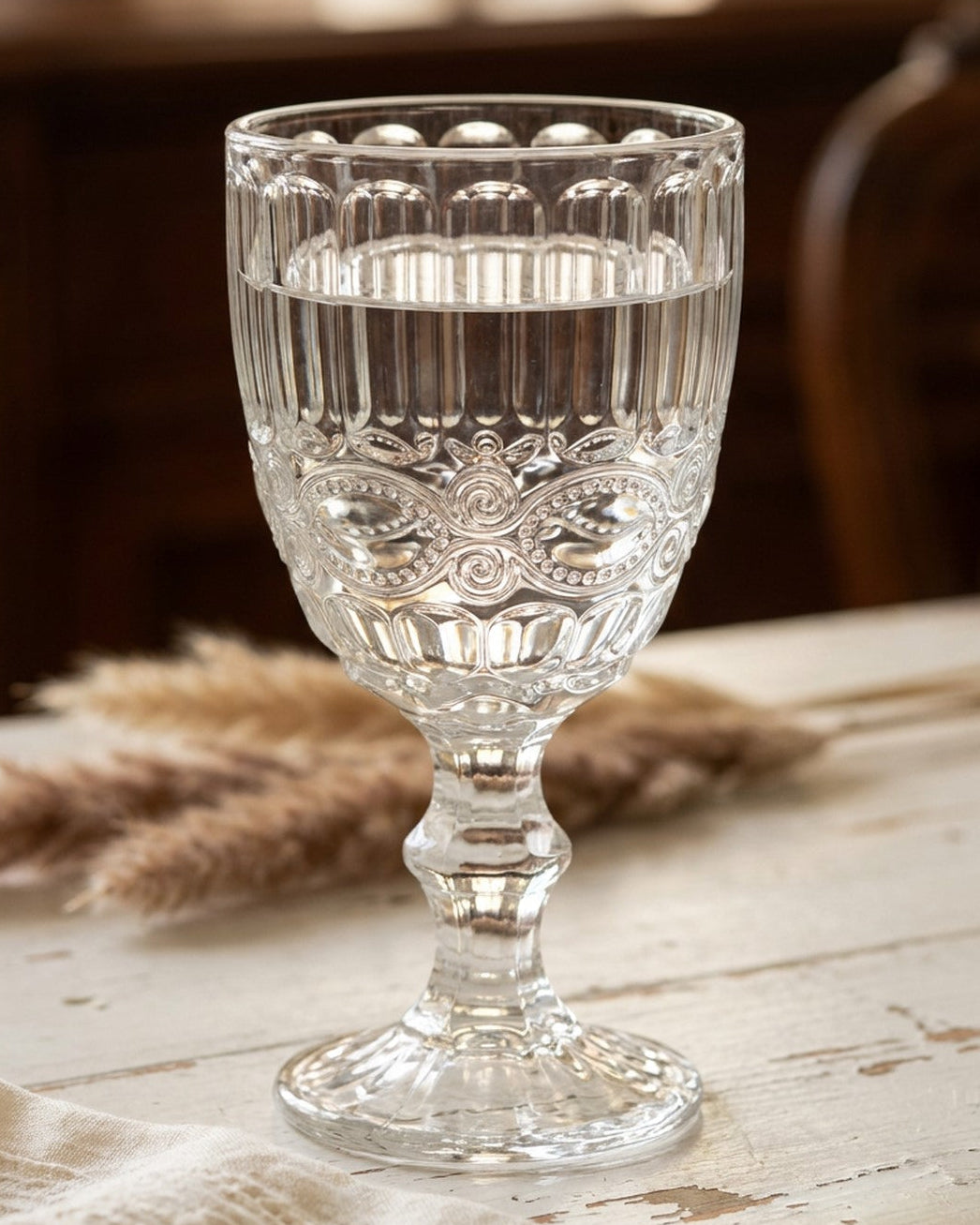 Set of clear glassware on a floral tablecloth with a blurred background