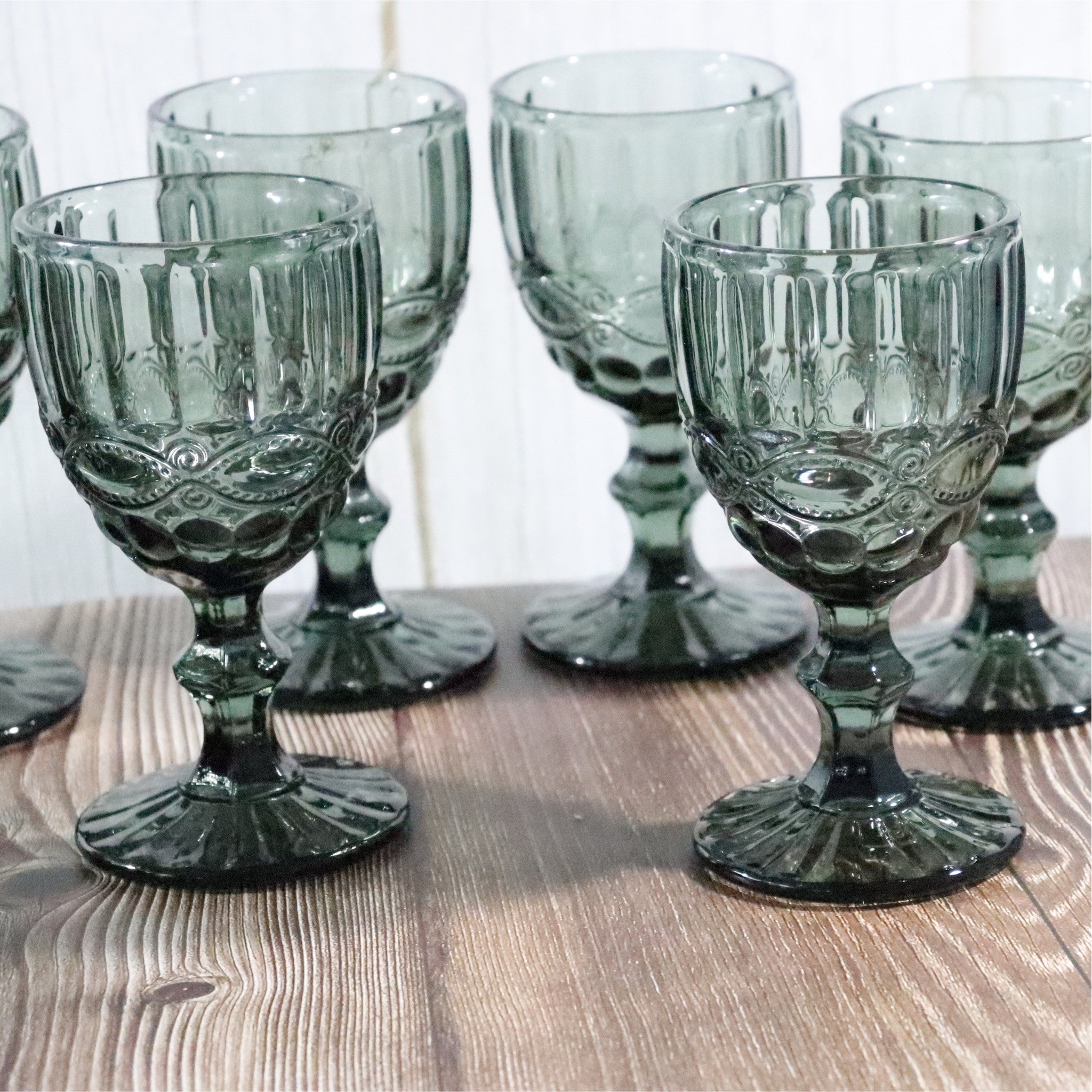 Set of grey glass goblets on a wooden surface