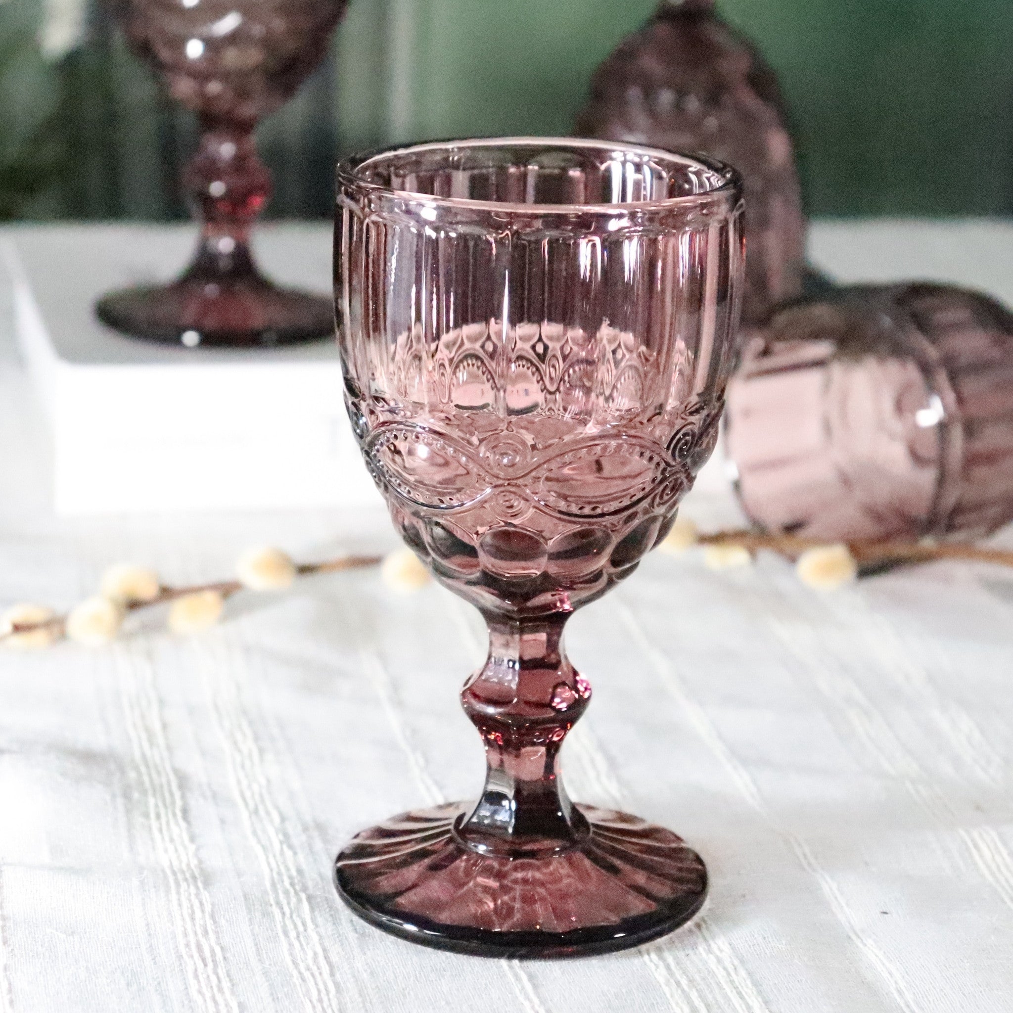 purple glass goblet with intricate patterns on a white surface