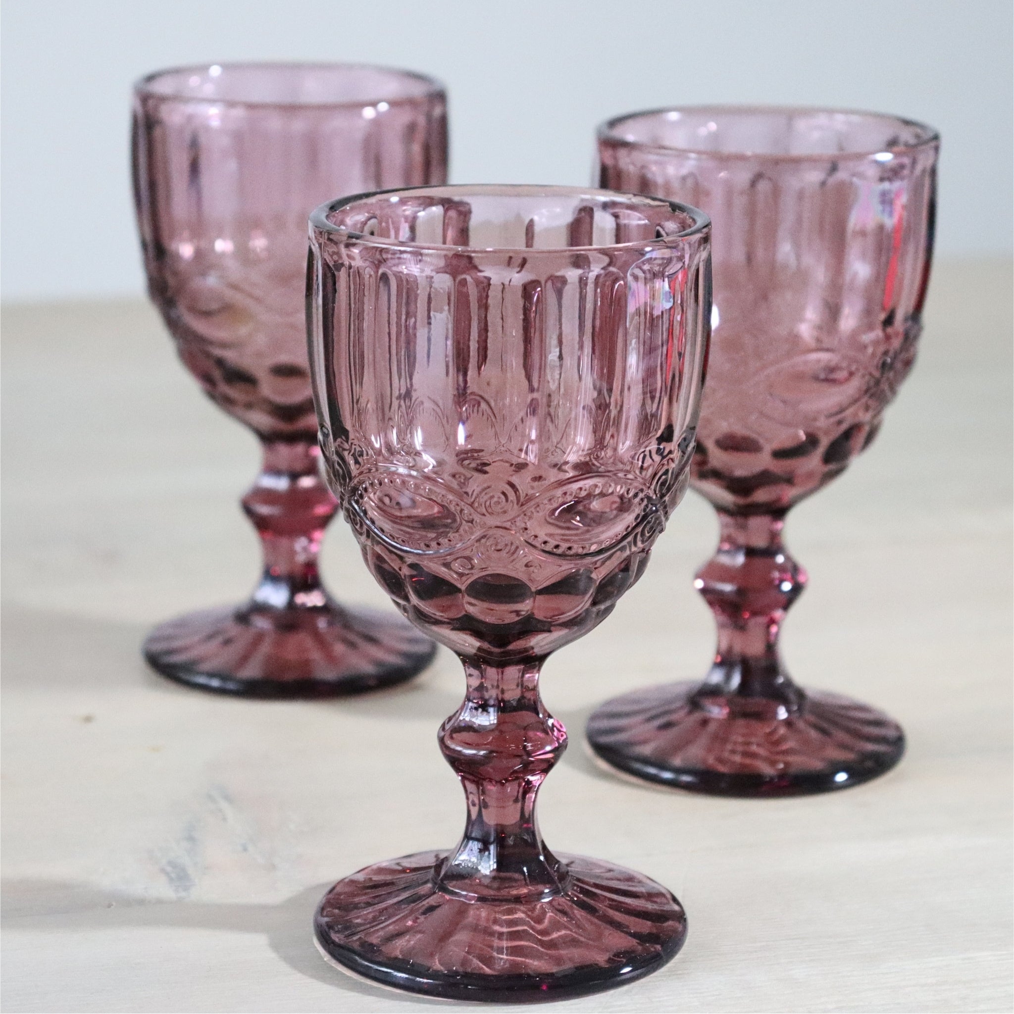 Purple textured glass goblet on a white background