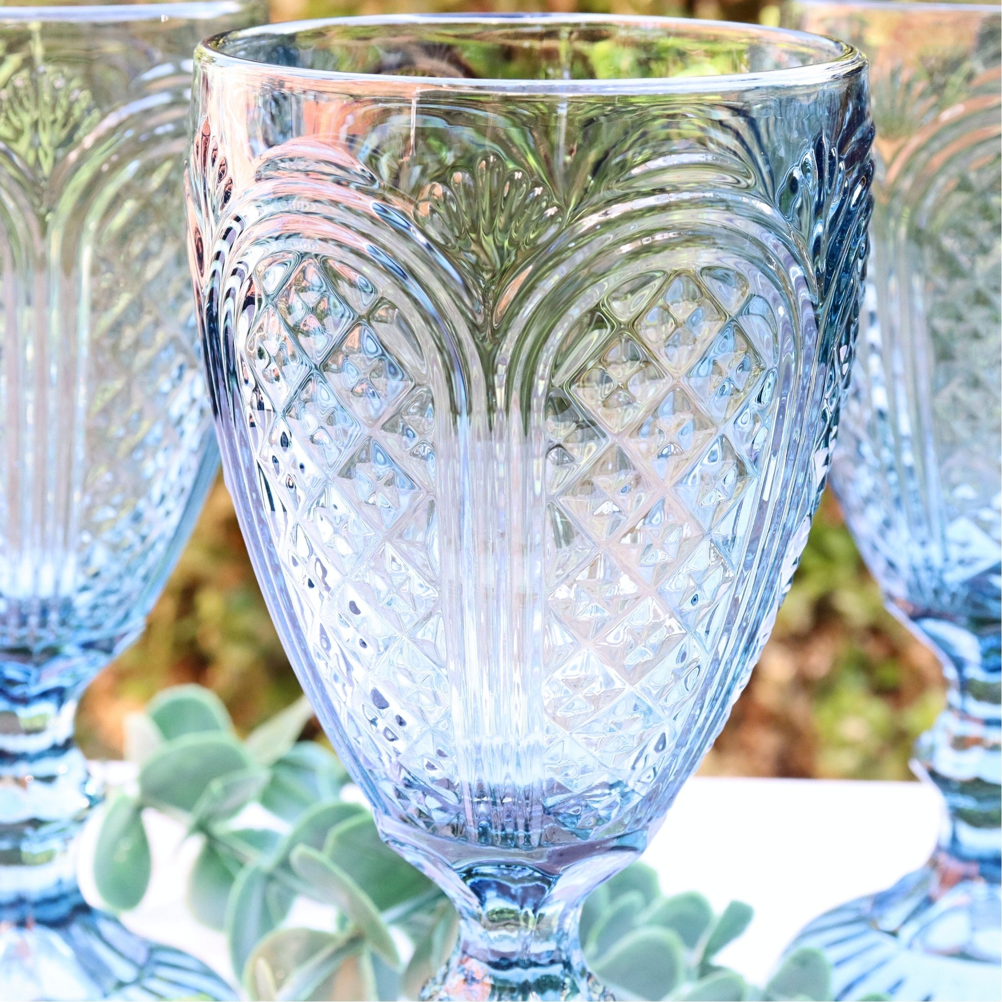 Decorative glass goblet with intricate patterns on a blurred natural background