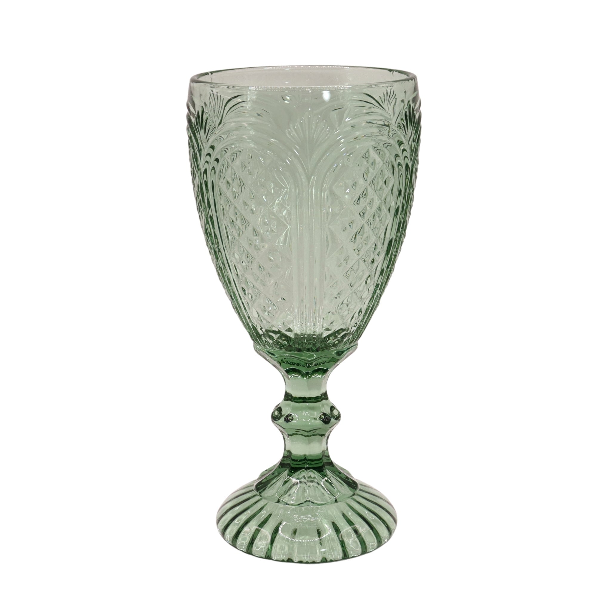 Green glass goblet with intricate patterns on a white background