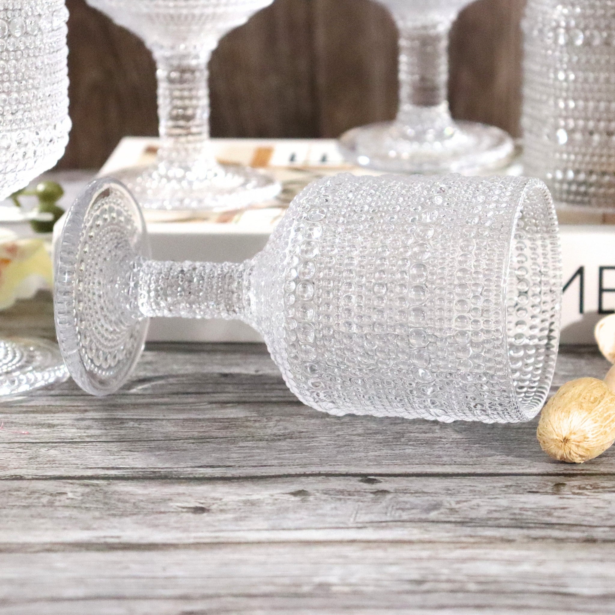 Decorative glass goblet with textured surface on a wooden surface