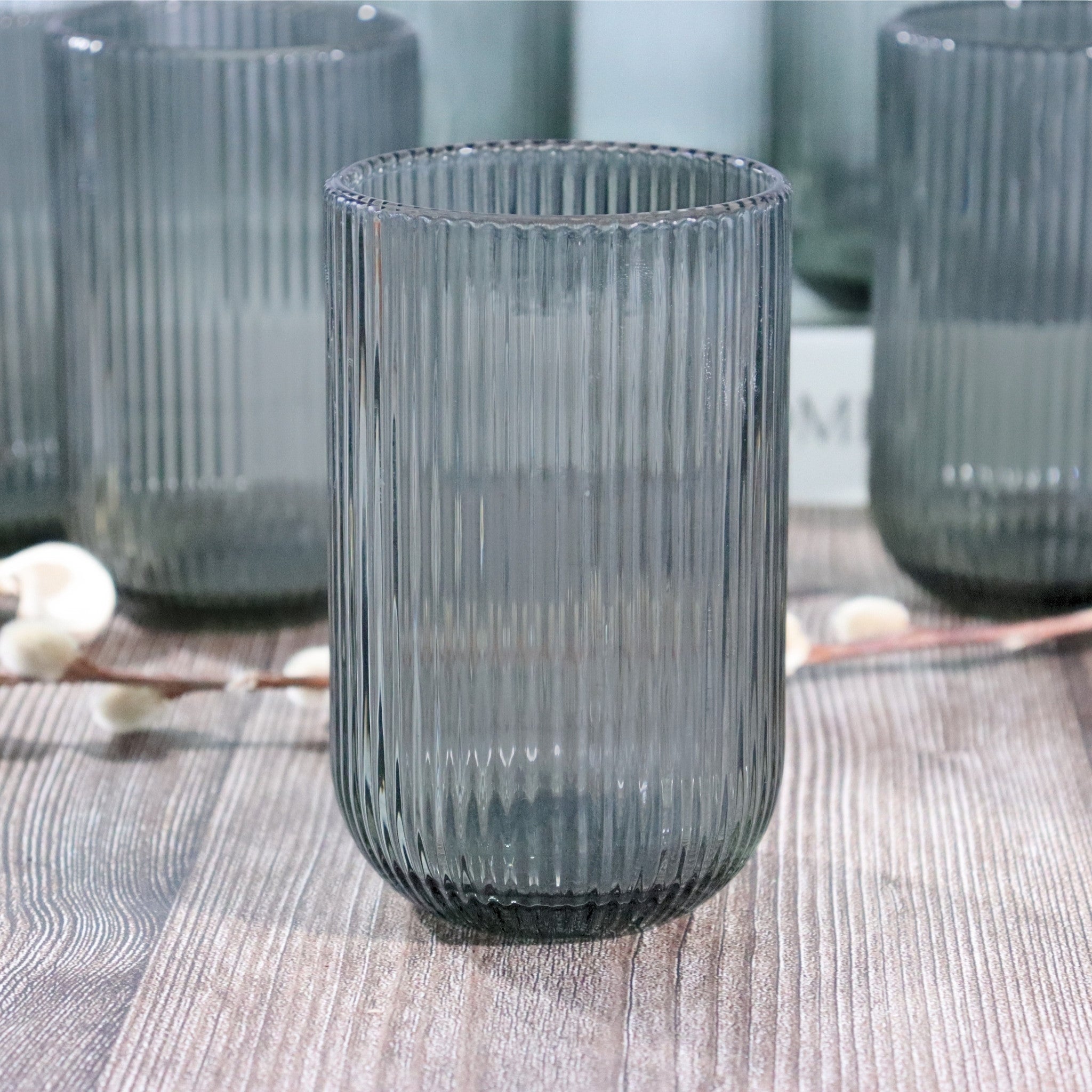 Set of ribbed glass tumblers on a textured surface
