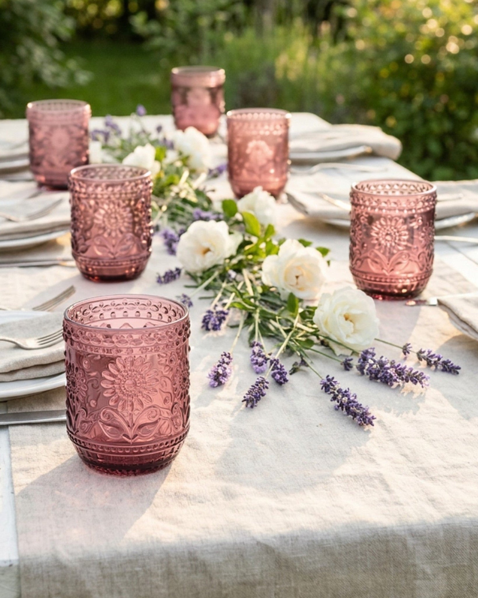 Pink glass tumblers on a table with white flowers and lavender