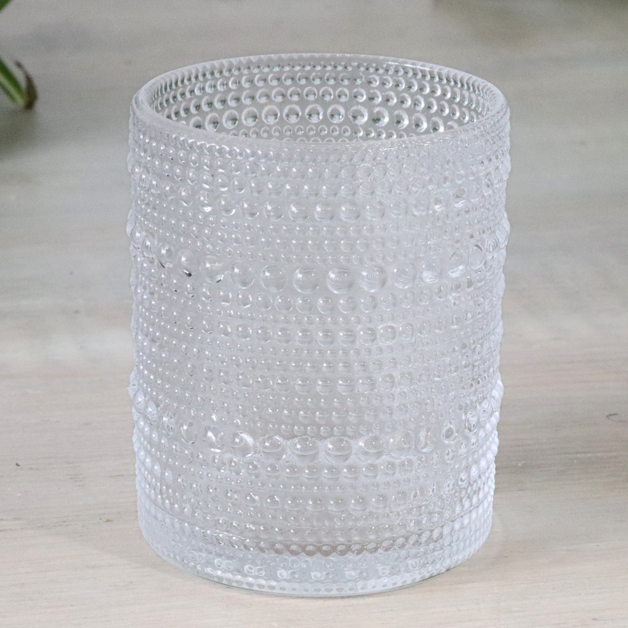 Clear hobnail glass tumblers on a wooden surface