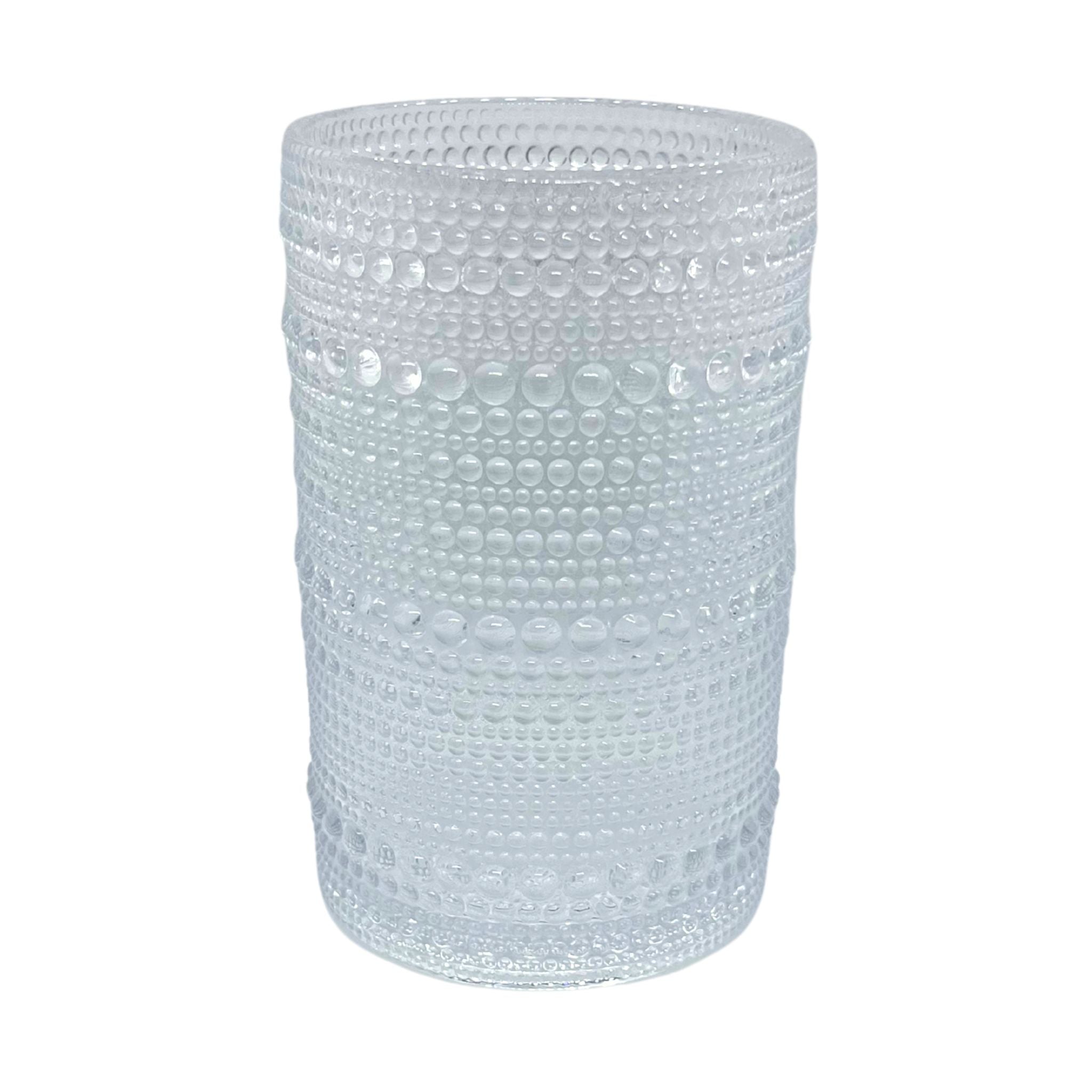 Clear textured glass tumbler on a white background