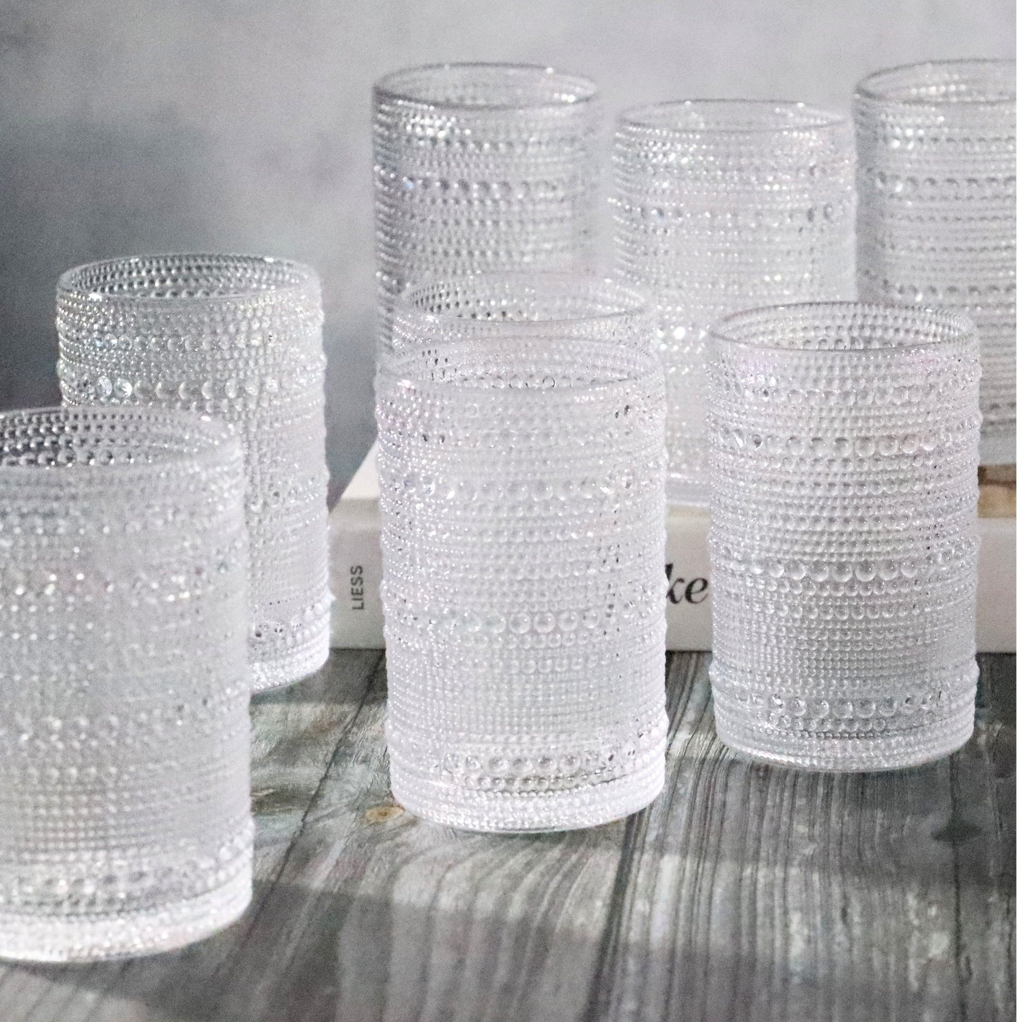 Set of jupiter beaded hobnail glass tumblers on a wooden surface with a neutral background
