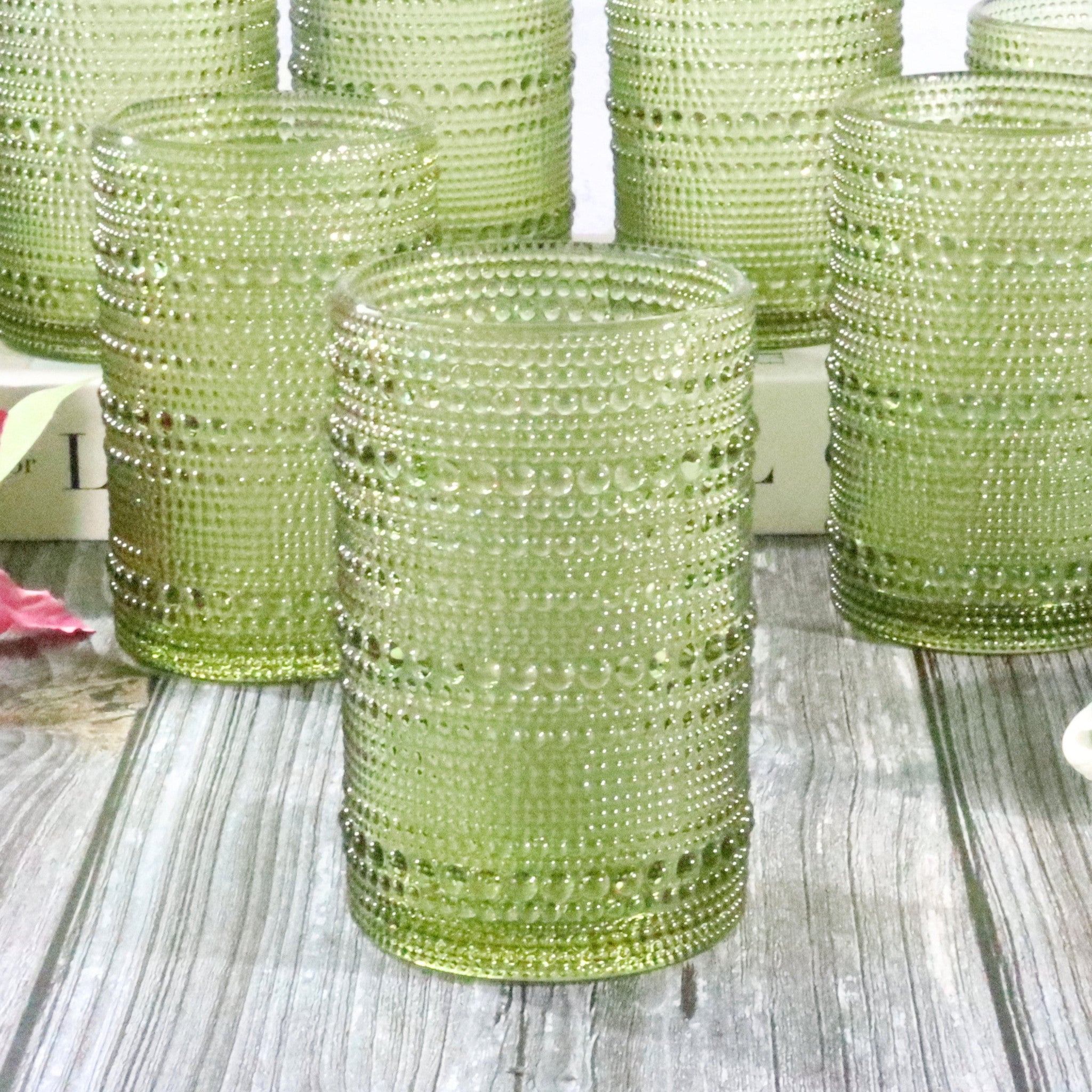 Green hobnail tumblers on a wooden surface