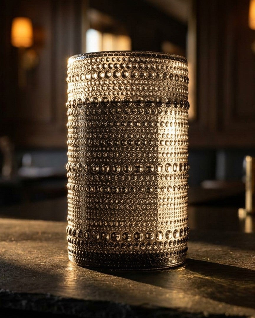 Set of hobnail bead grey tumblers on a wooden surface with a magazine in the background.