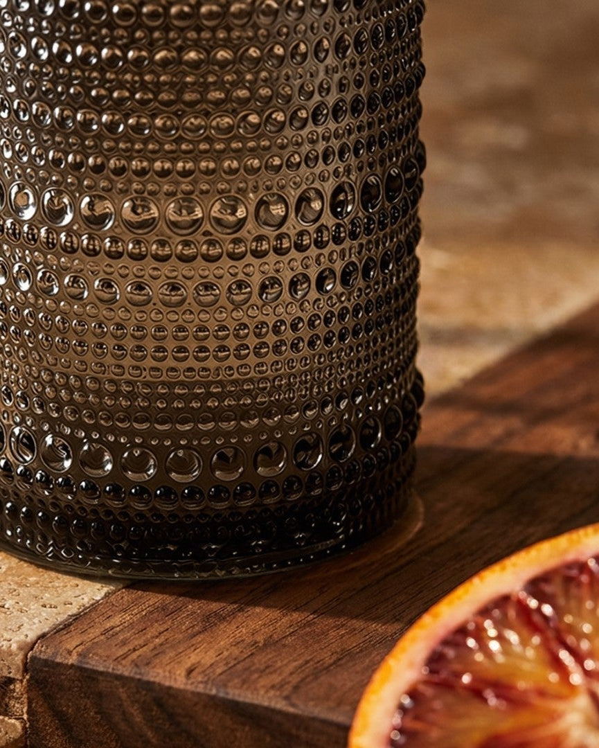 Grey Set of hobnail bead glass tumblers on a wooden surface with a light background