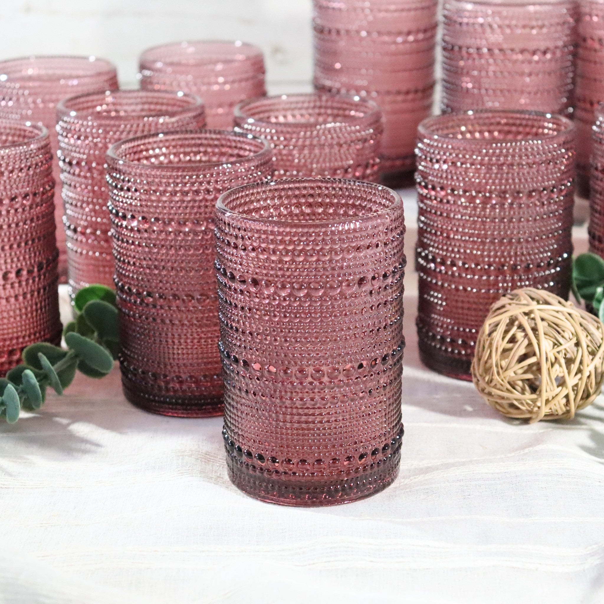 Purple beaded glasses on a white surface with decorative elements.