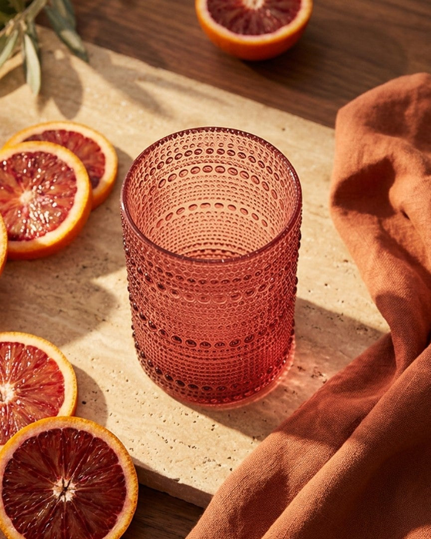 Set of purple textured glasses on a white surface with decorative elements.