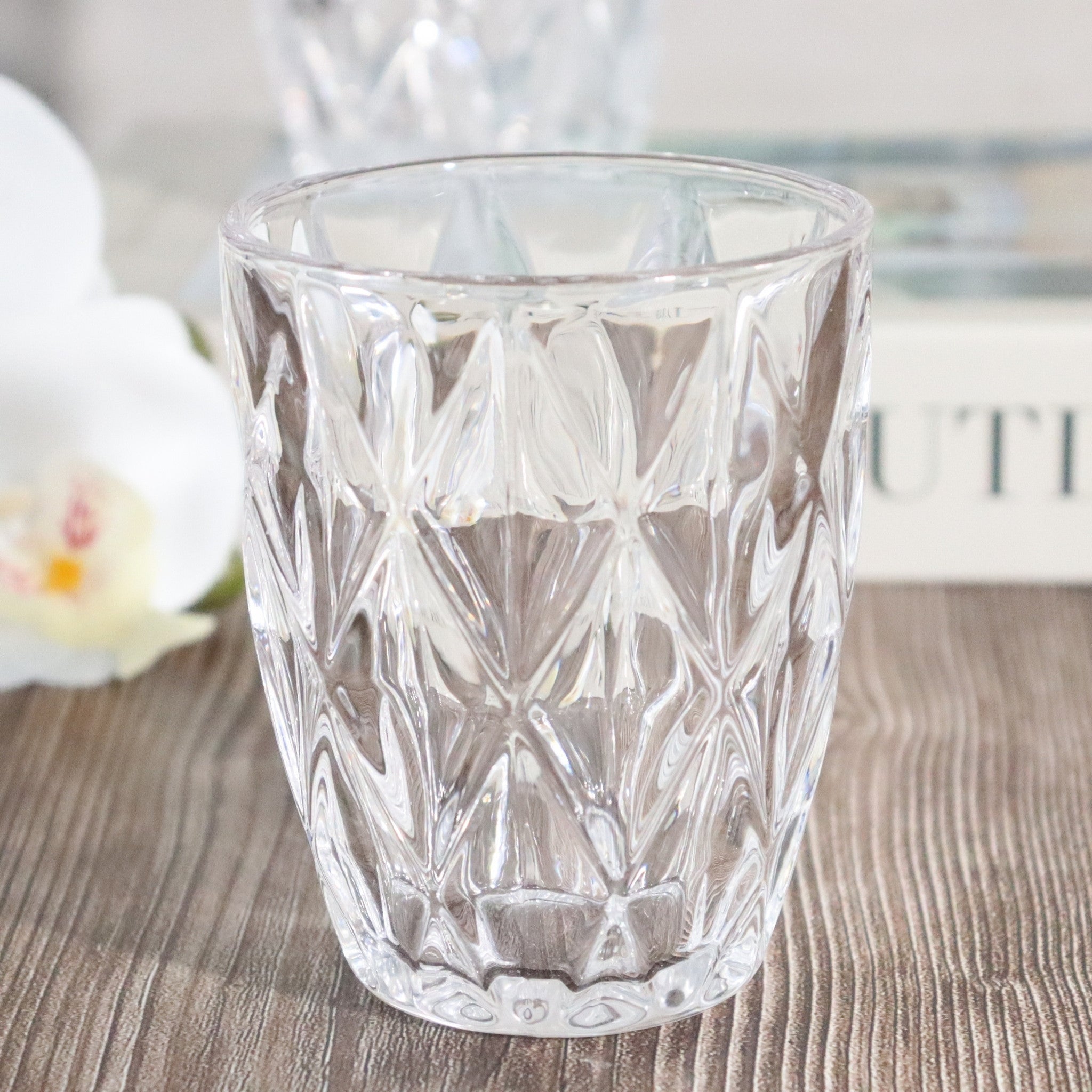 Clear glass with diamond pattern on a wooden surface