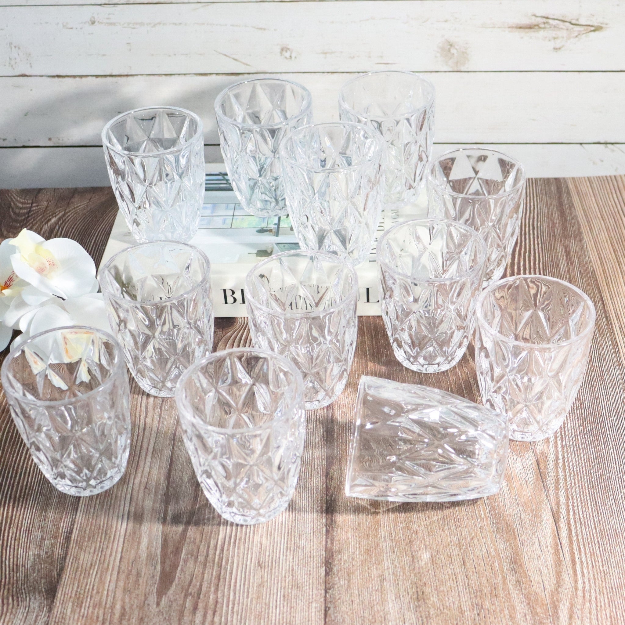 Set of crystal glasses on a wooden surface with a white background