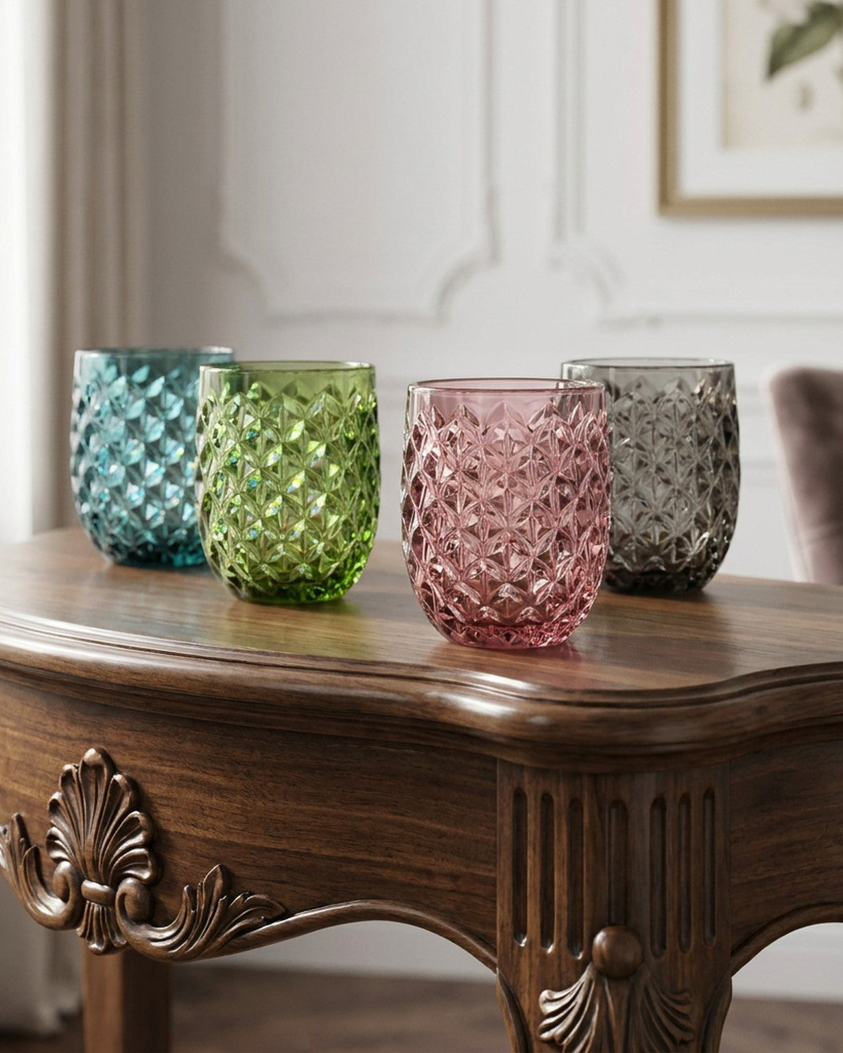 Four colorful glass tumblers on a wooden table with a neutral background