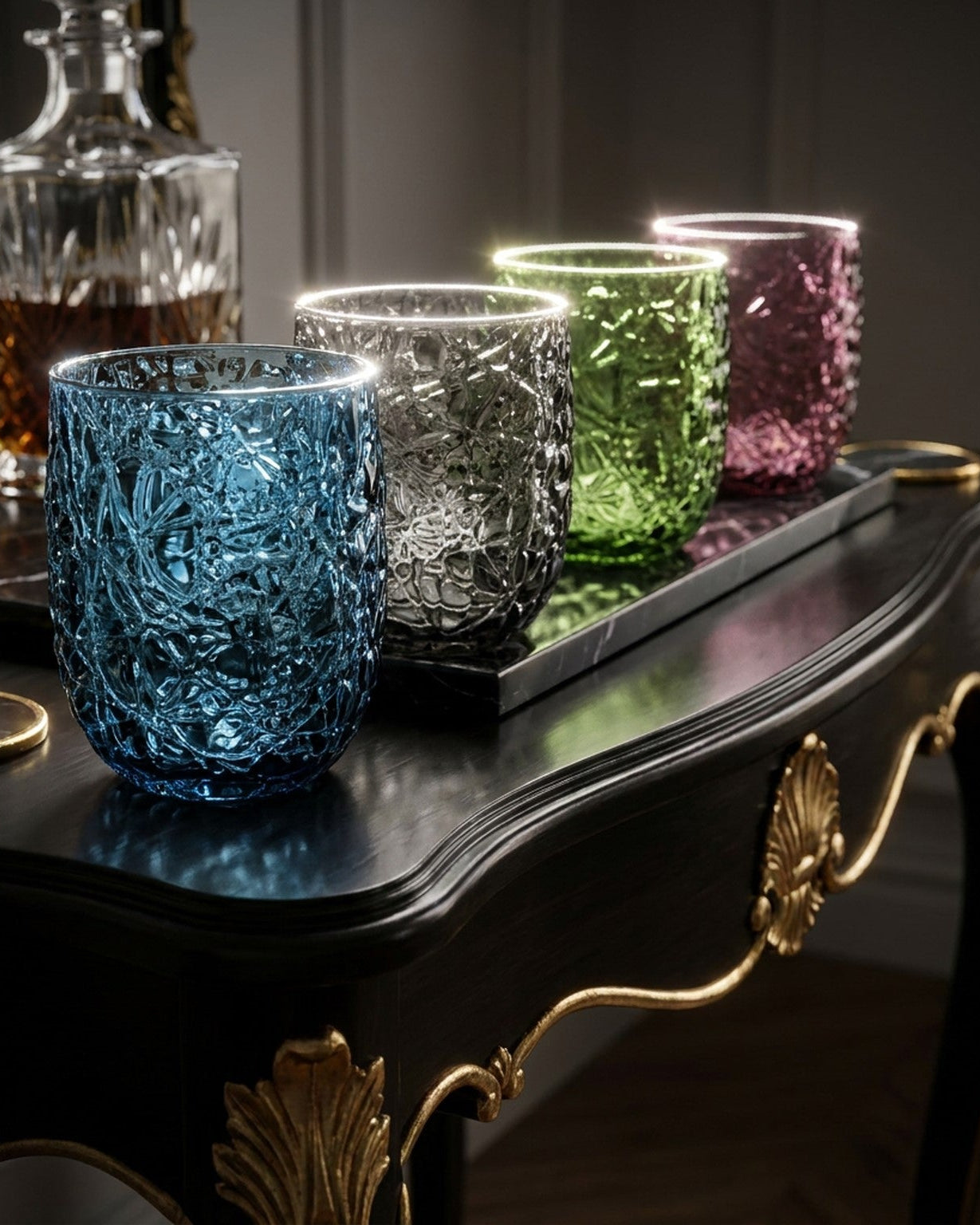 Colorful textured glass tumblers on a dark wooden table with gold accents
