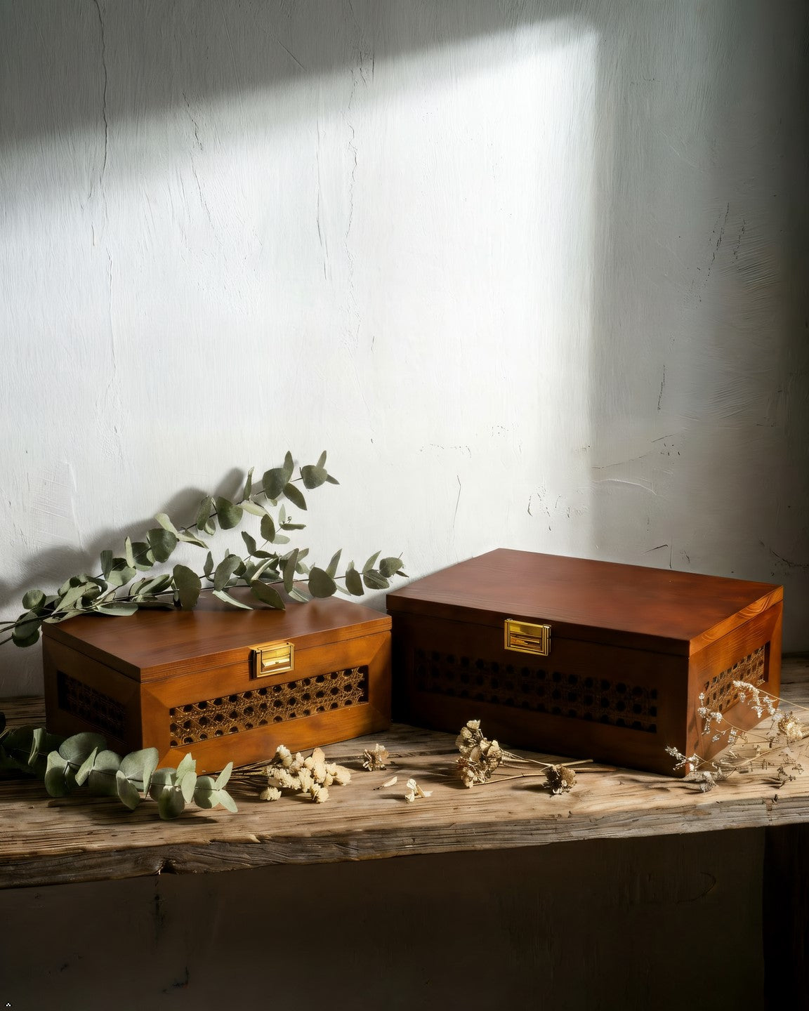 Two wooden boxes with decorative elements on a textured surface