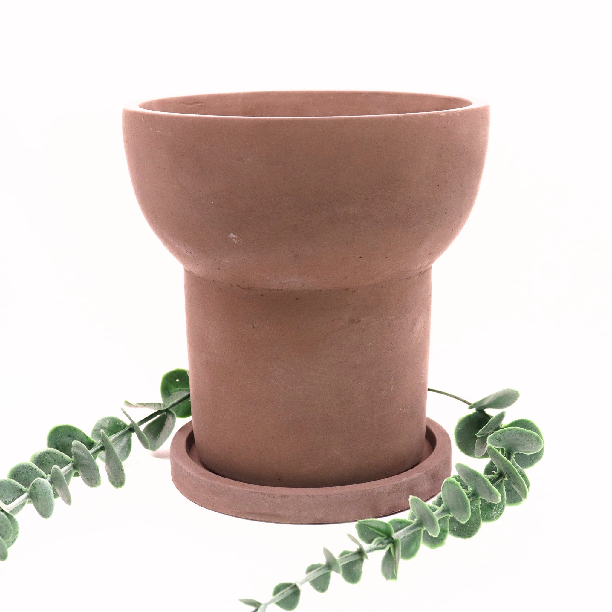Terracotta pot with a matching saucer on a white background