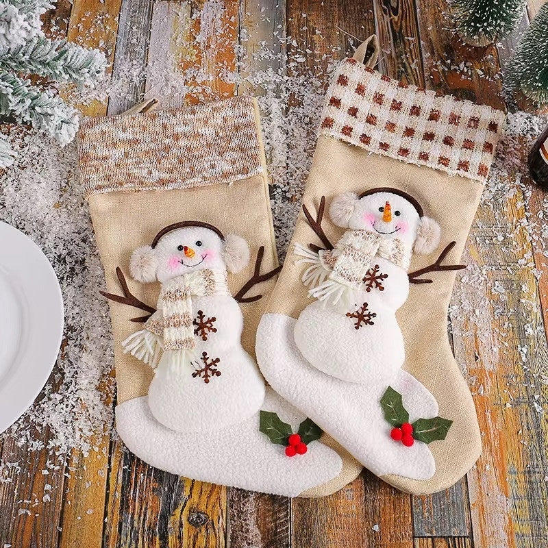 Two Christmas stockings with snowman designs on a wooden surface.