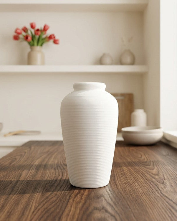 White vase on a wooden surface with a neutral background