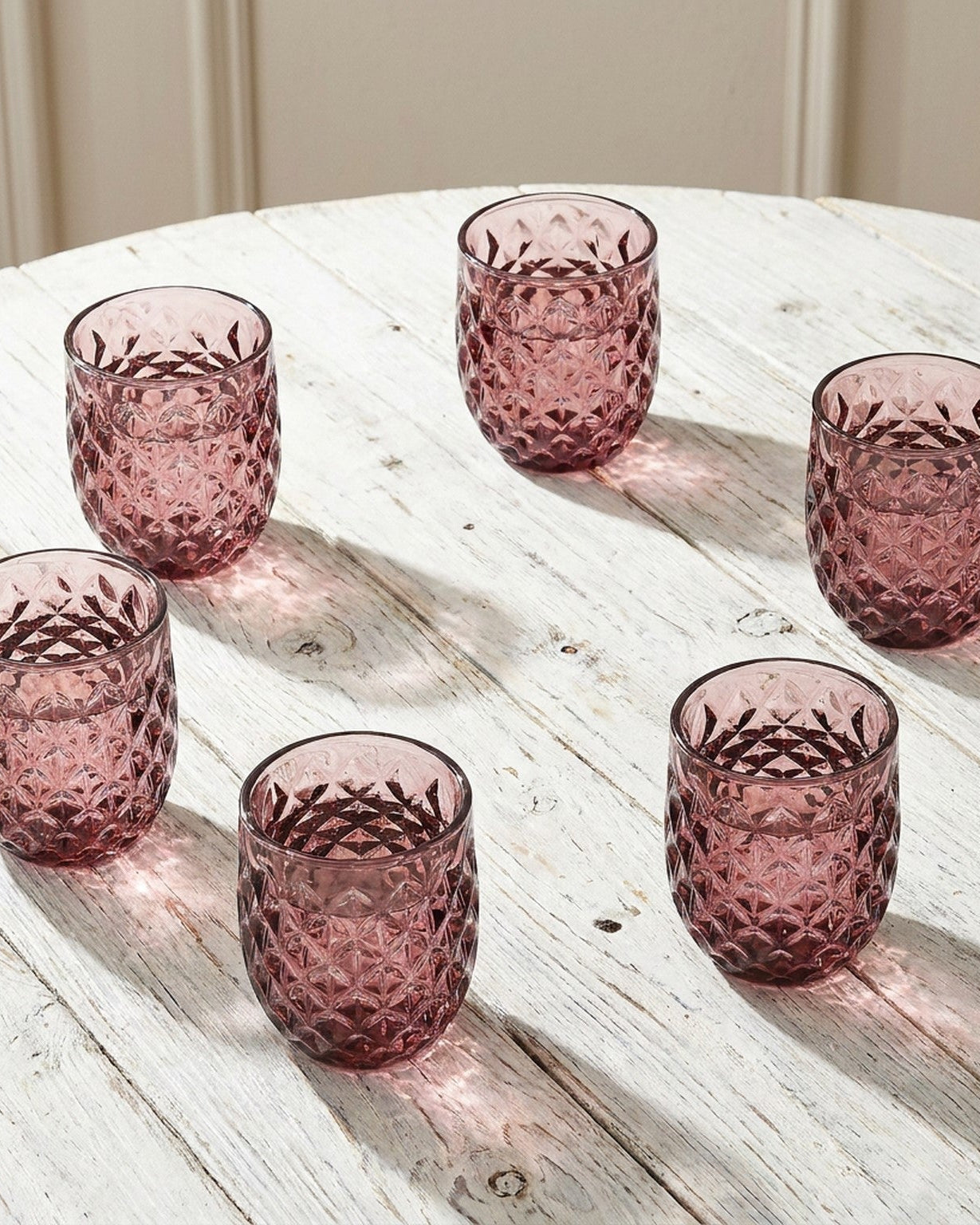 purple glass tumbler with textured design on a marble surface