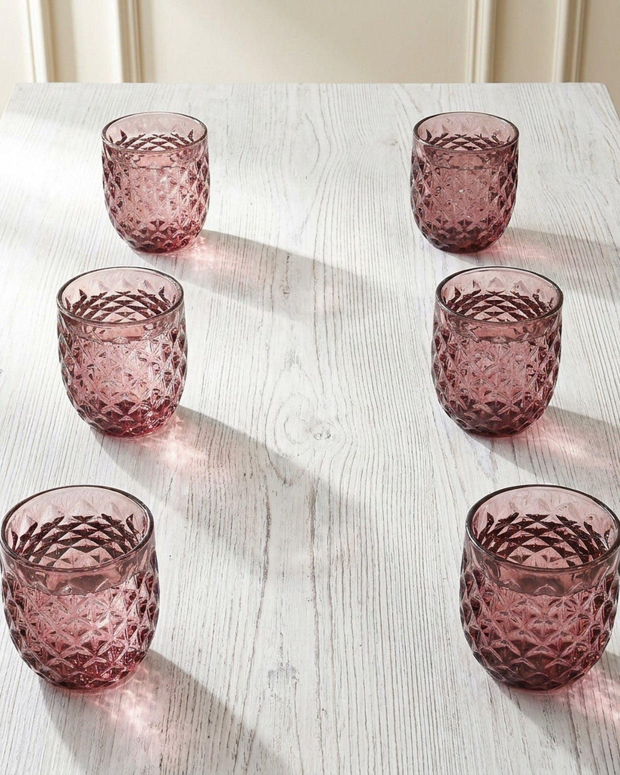 Set of four purple textured glass tumblers on a light background