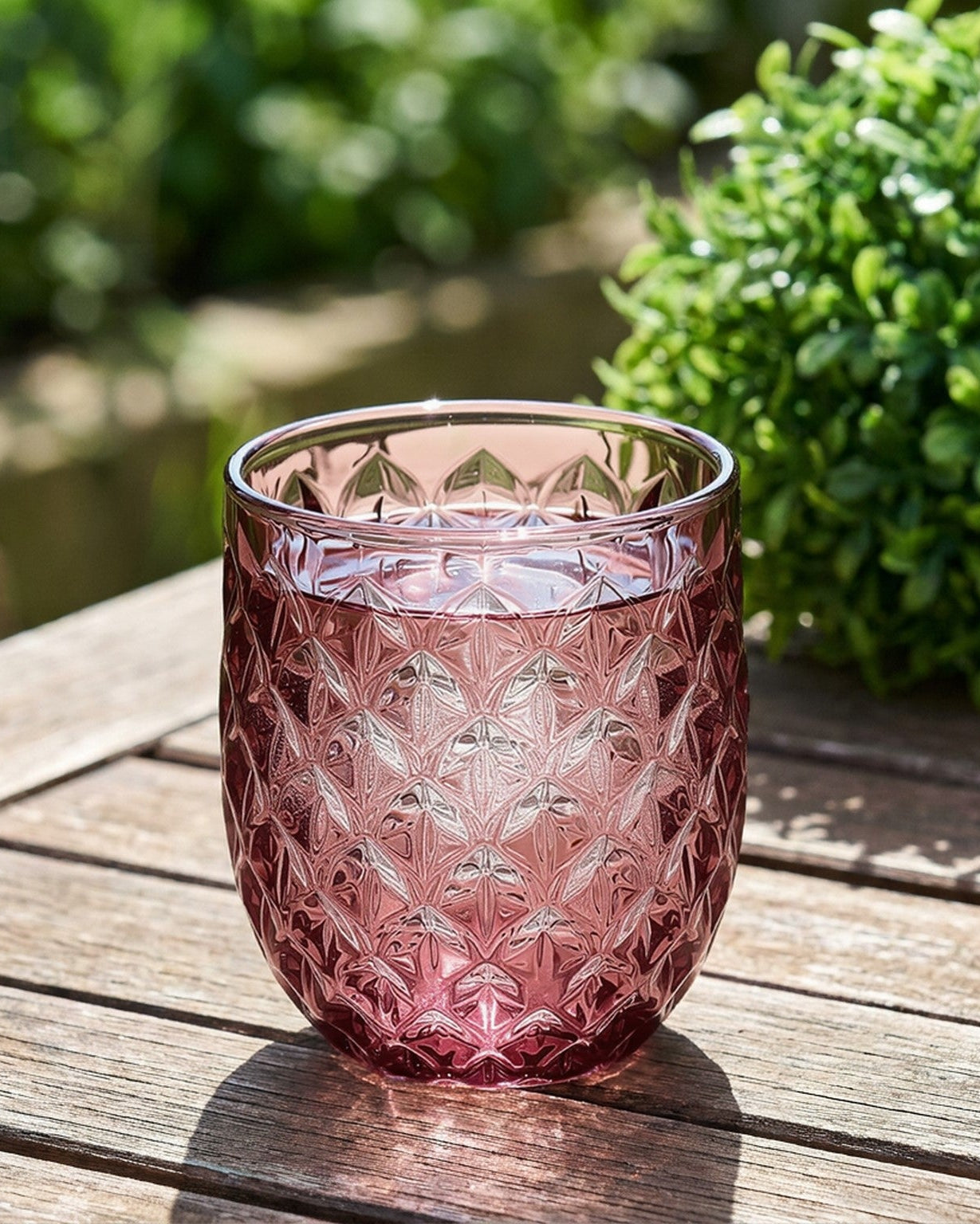Set of purple glass tumblers with diamond pattern on a marble surface