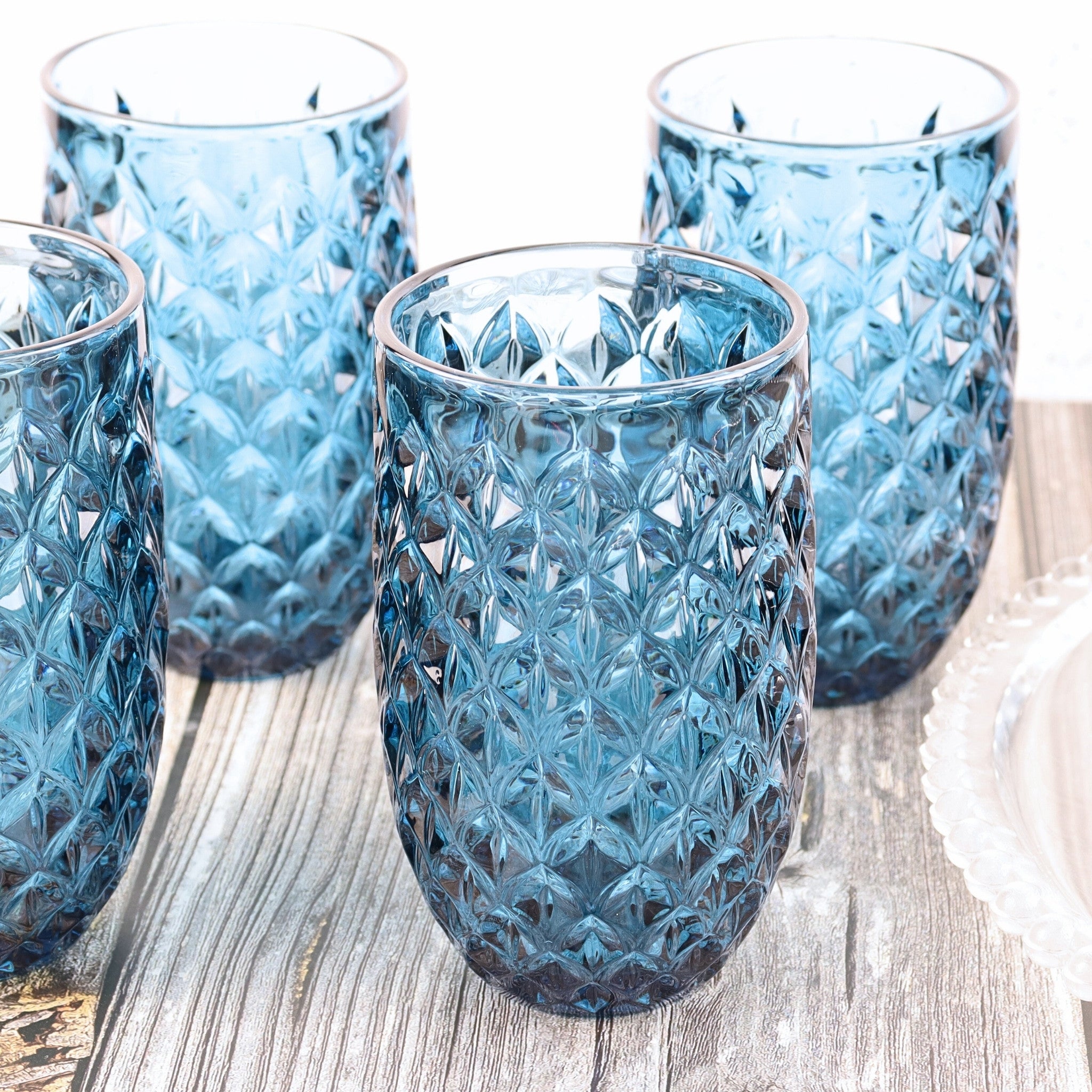 Set of blue textured glass tumblers on a wooden surface