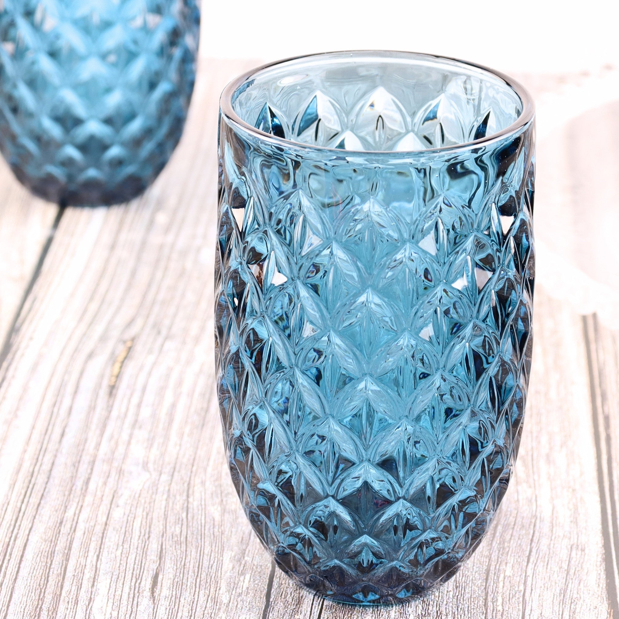 Blue textured glass tumbler on a wooden surface