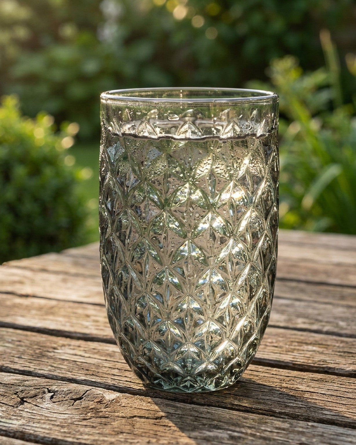 Clear glass tumbler with diamond pattern on a wooden surface