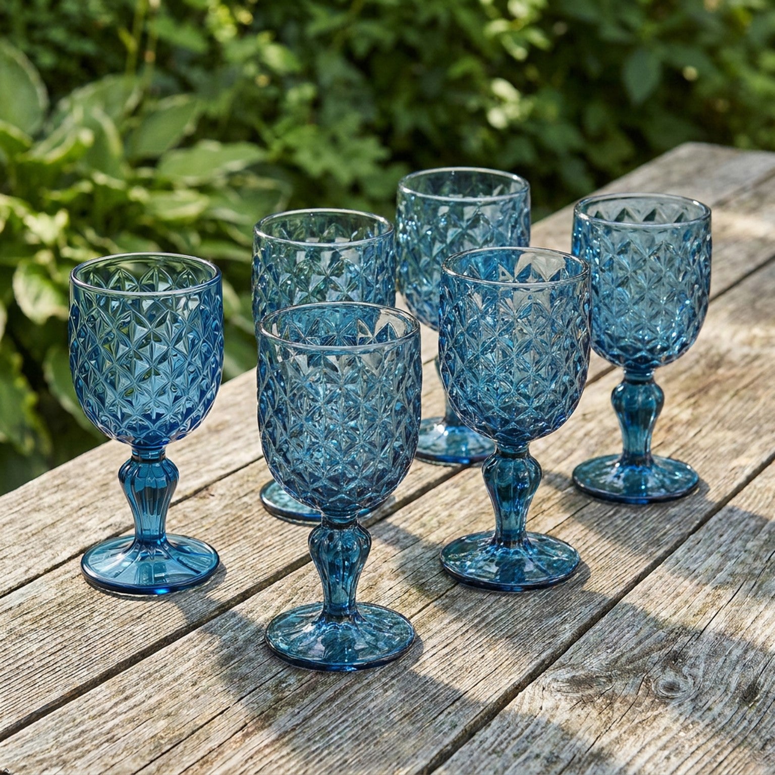 Set of blue textured glass goblets on a light gray surface