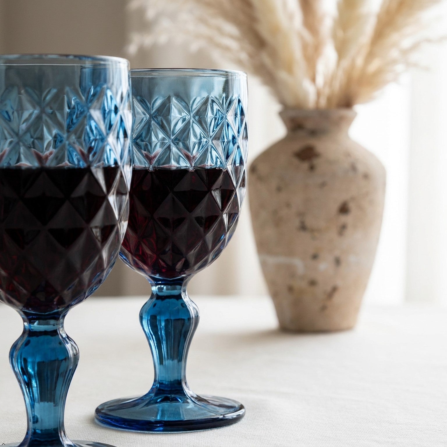 Set of blue textured glass goblets on a light gray surface