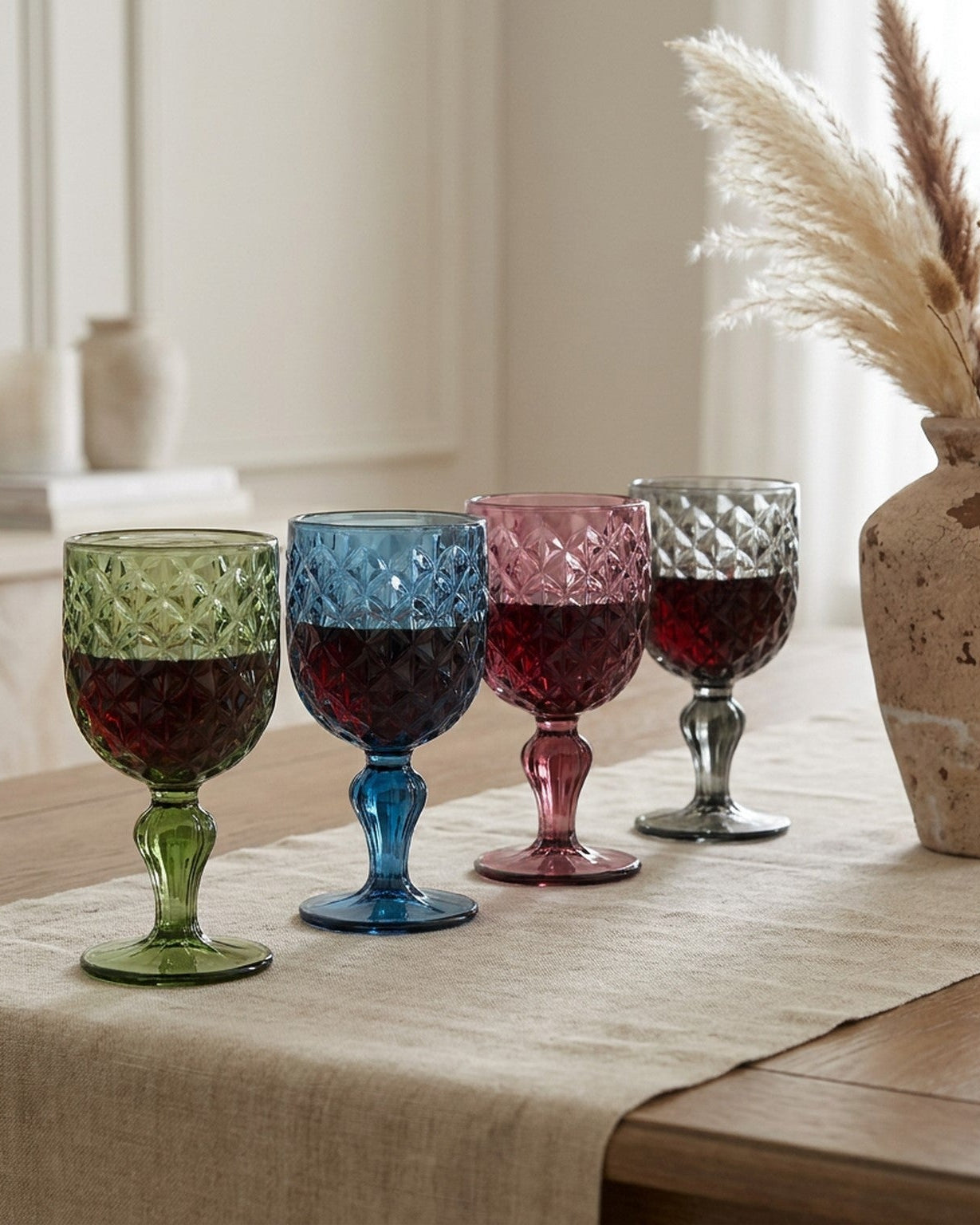 Four colorful glass goblets on a marble surface