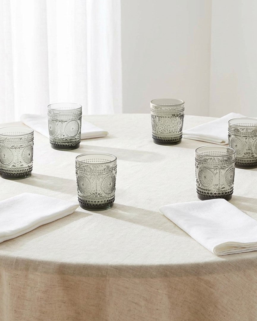 Set of green patterned glass tumblers on a white surface
