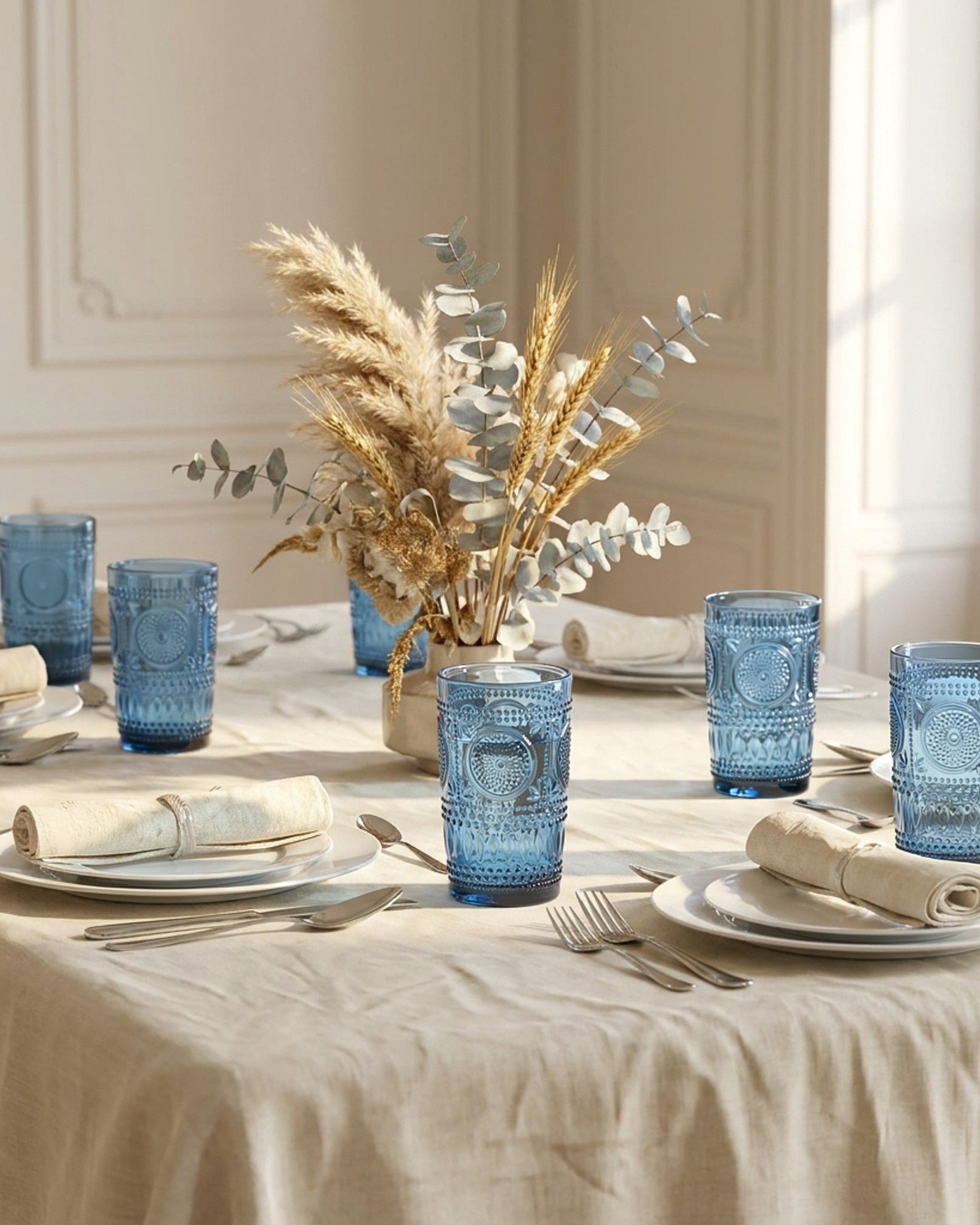 Set of six blue glass tumblers with textured design on a light surface.