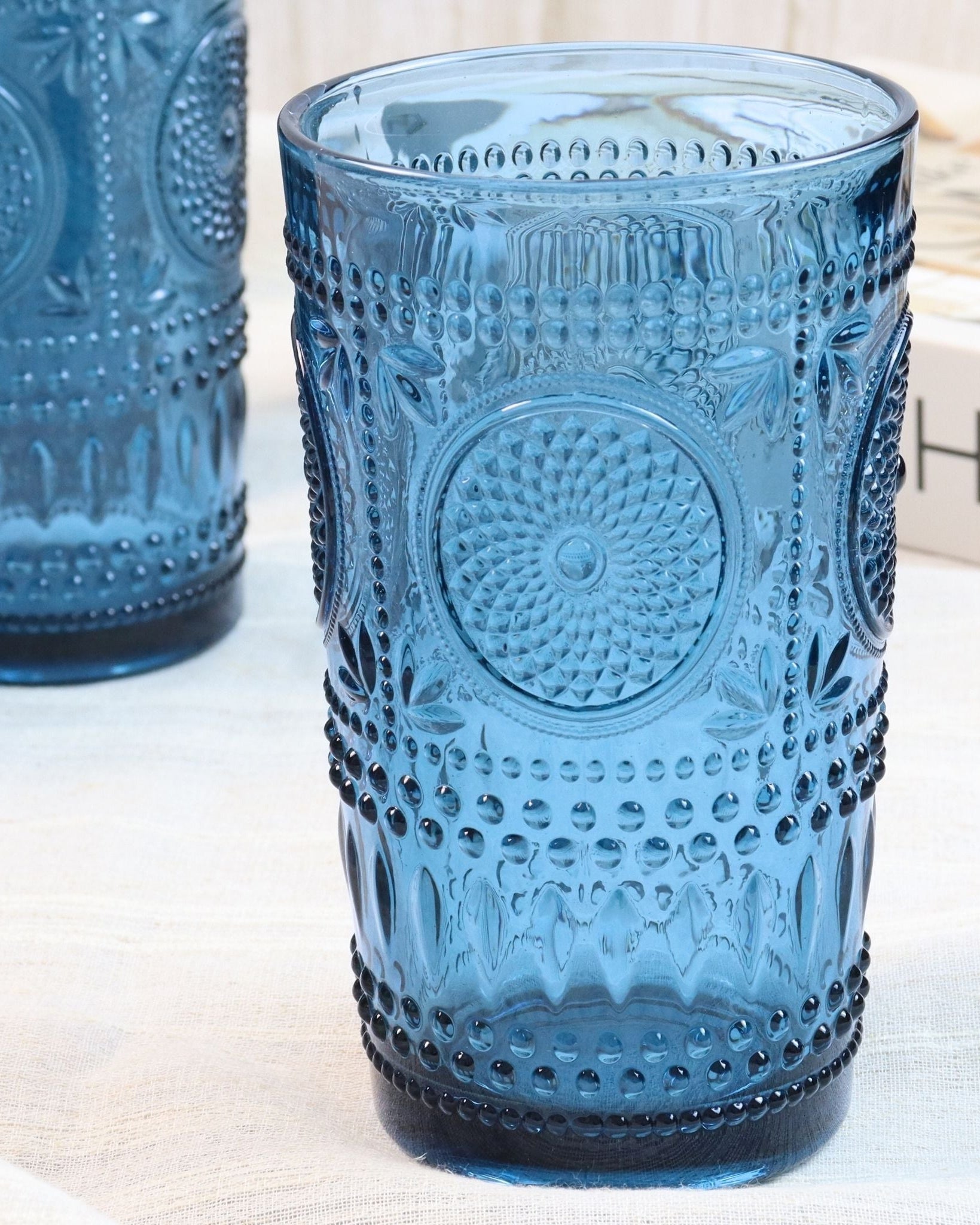 Two blue textured glass tumblers on a light surface.