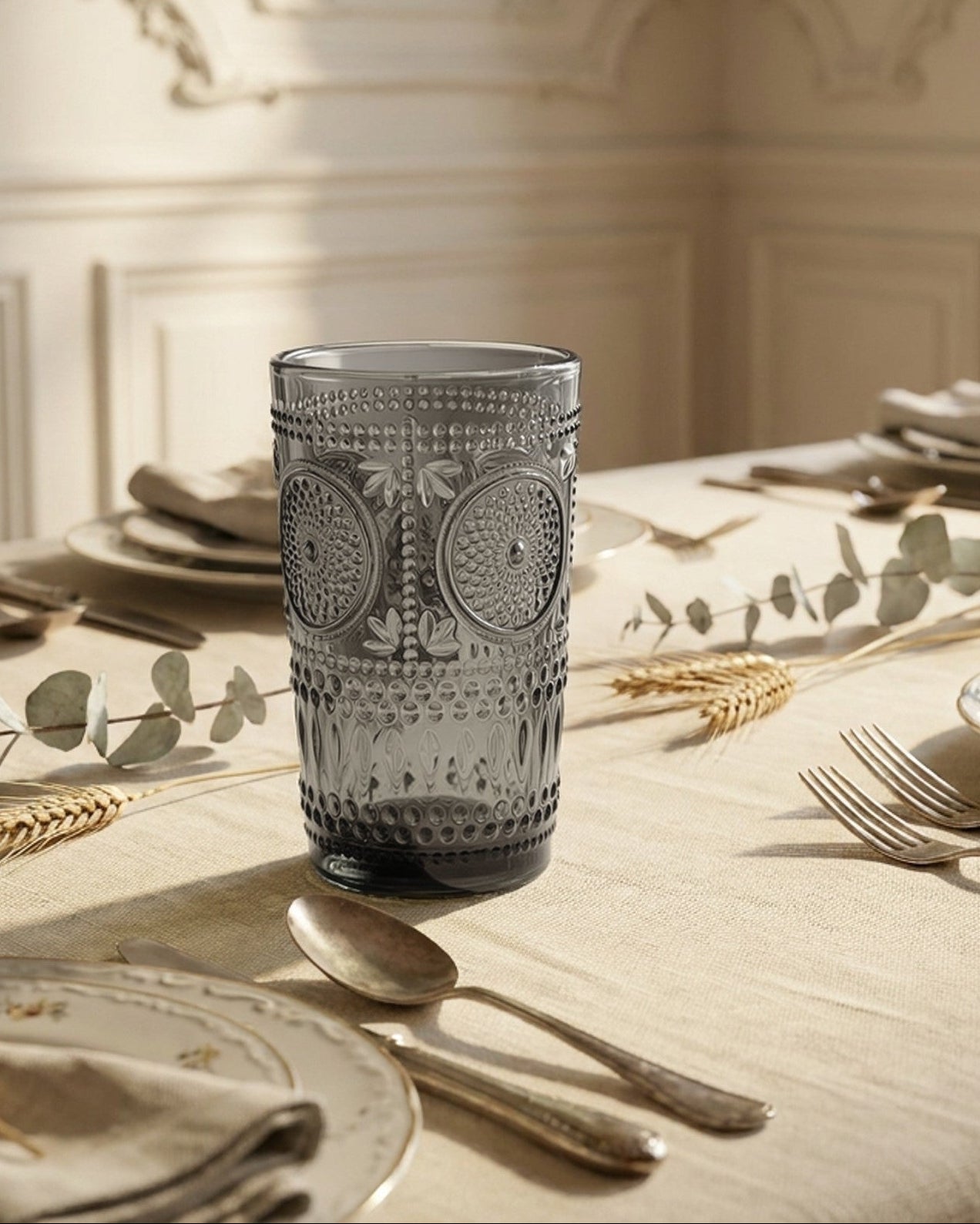 Decorative glass tumbler with textured design on a white surface