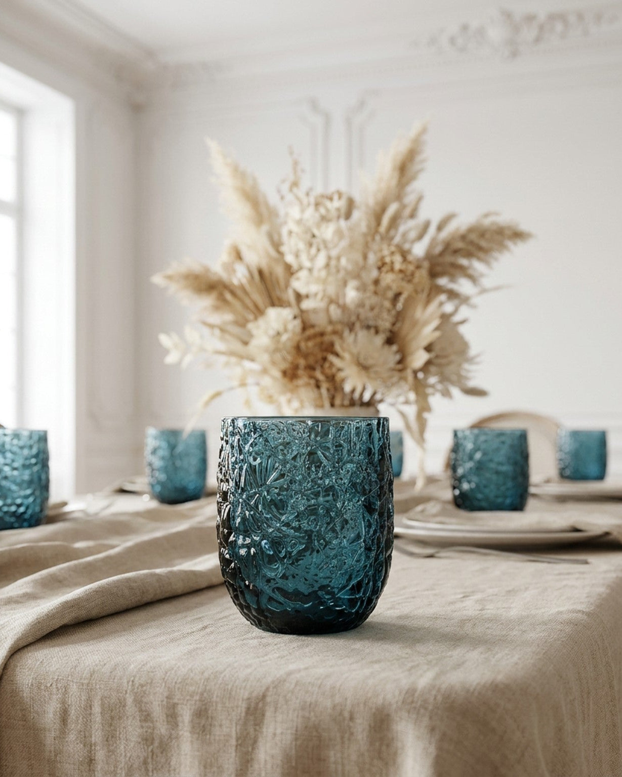 Set of blue textured glasses on a white surface with a wooden background