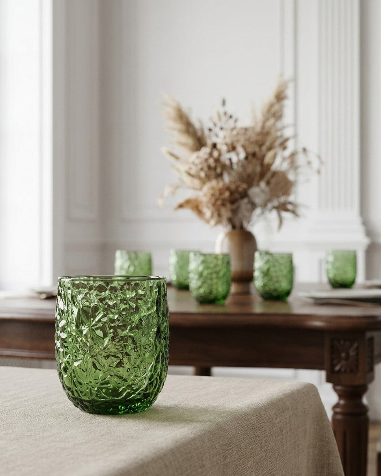 Green textured glass tumblers on a white surface