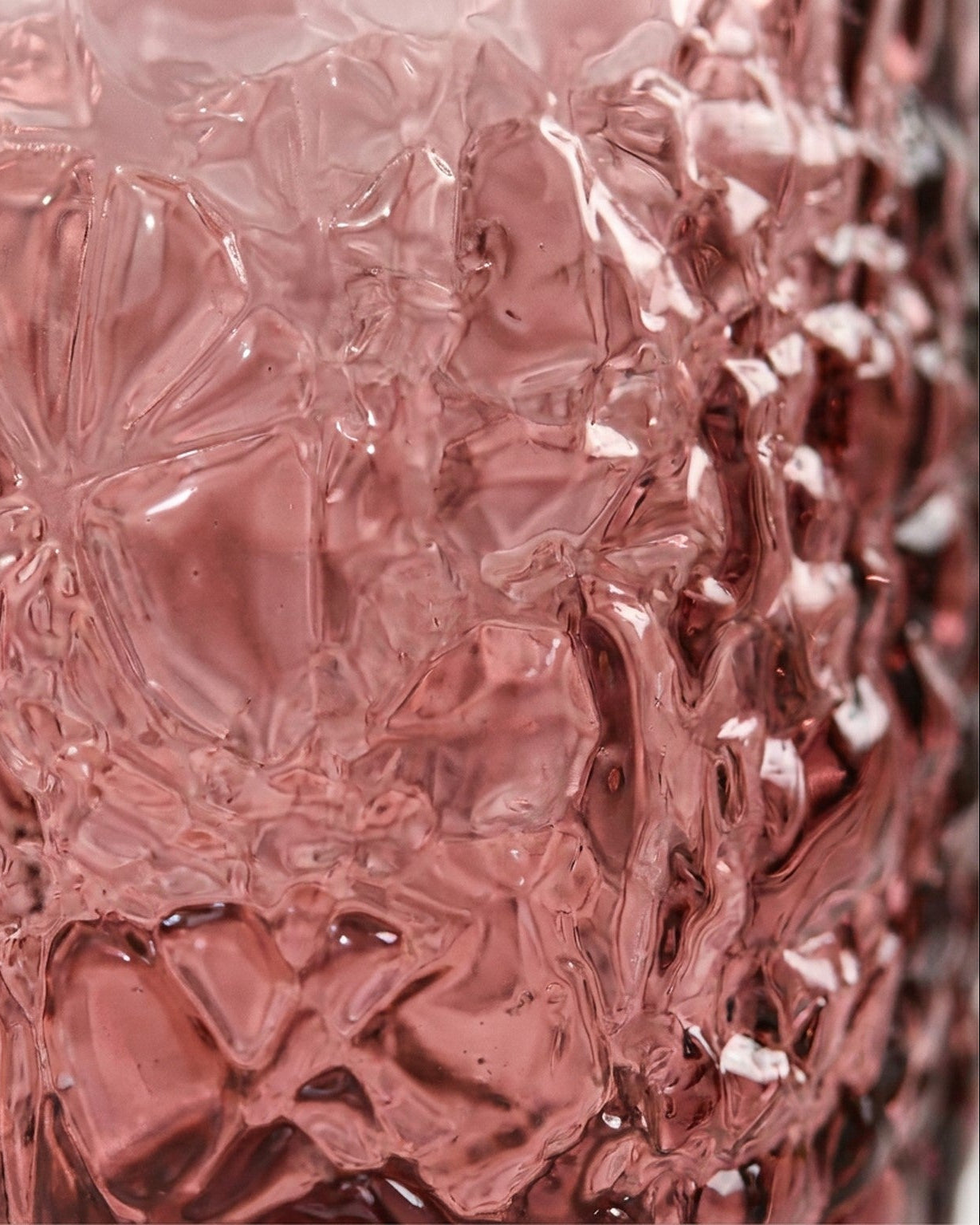 Set of purple textured glass tumblers on a marble surface with a light gray background