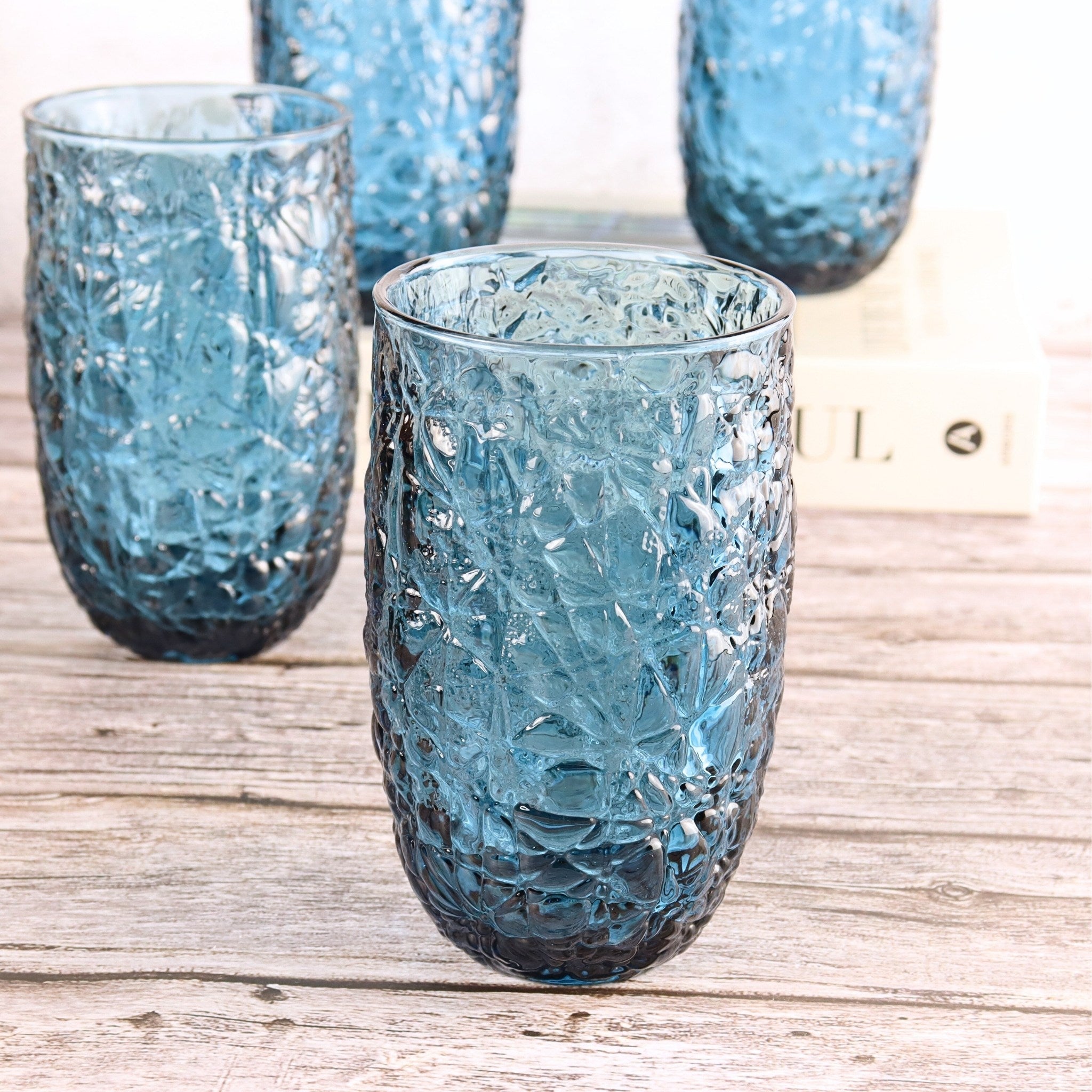 Set of blue textured glass tumblers on a wooden surface