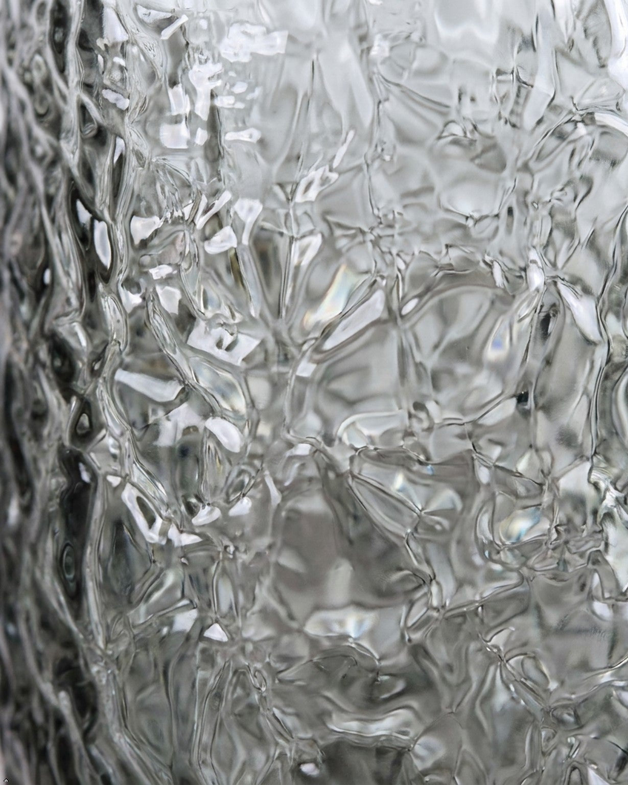 Set of textured glass tumblers on a wooden surface with white flowers.
