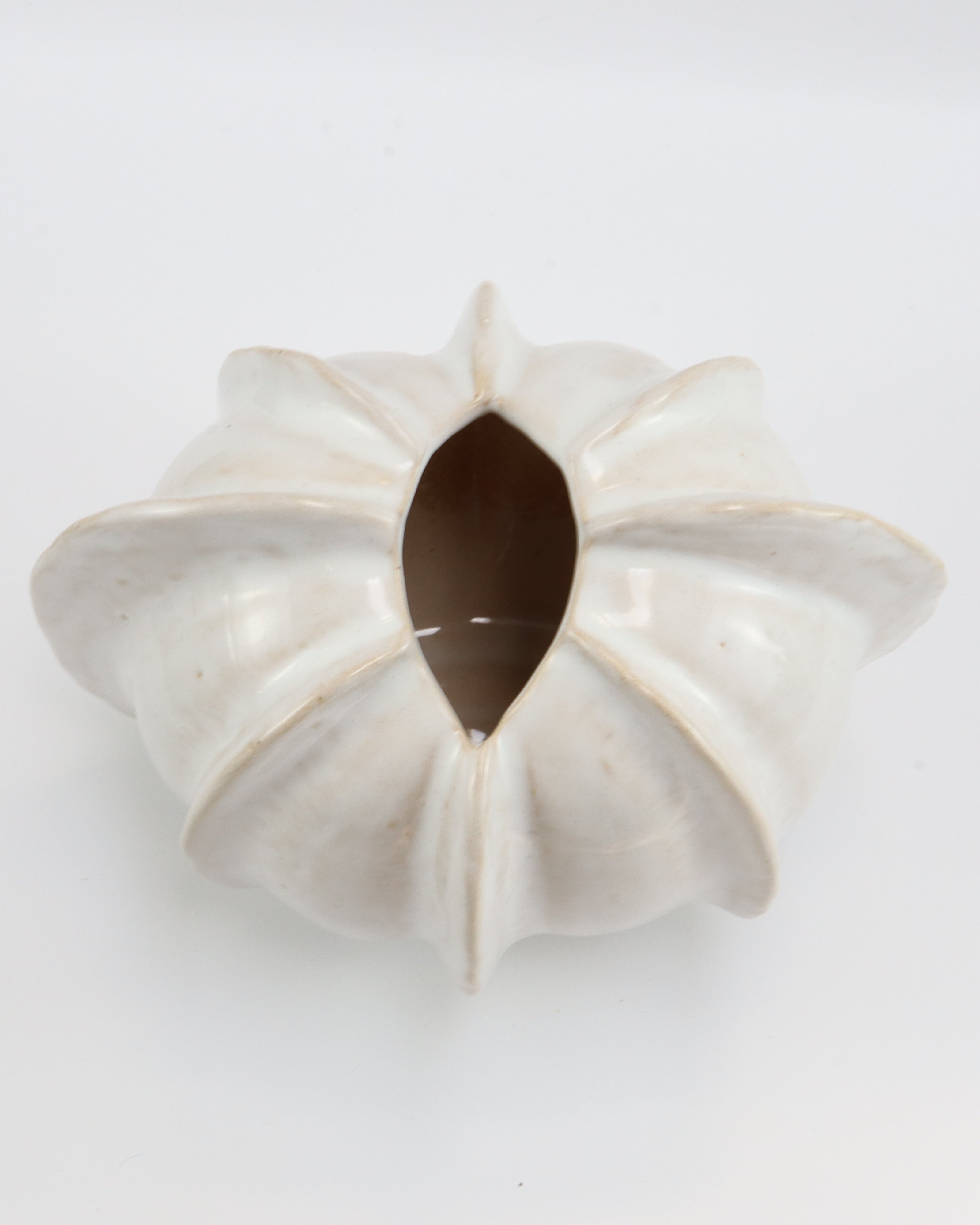White ceramic vase with a unique design on a light gray background