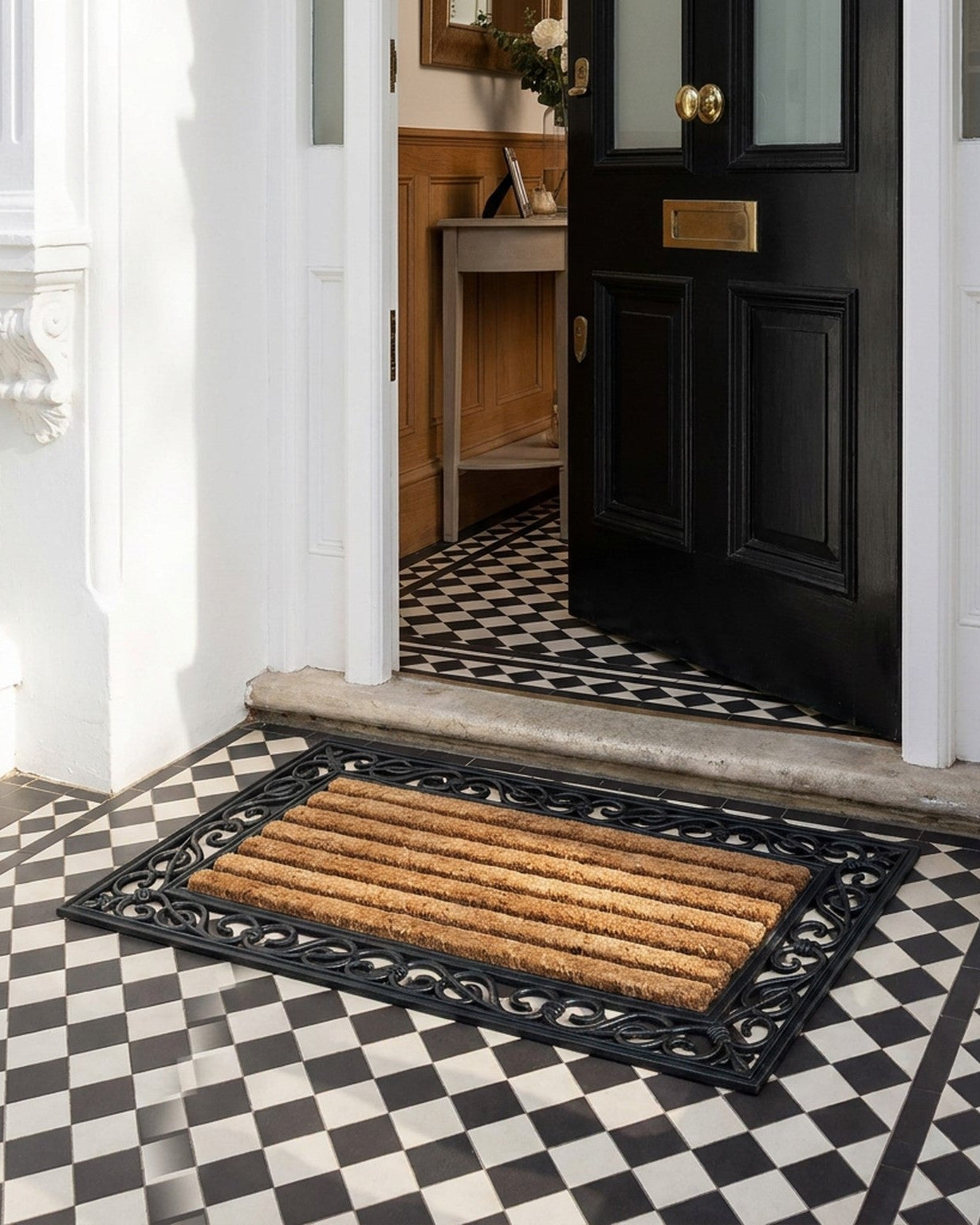 Doormat in front of a black door with a checkered floor